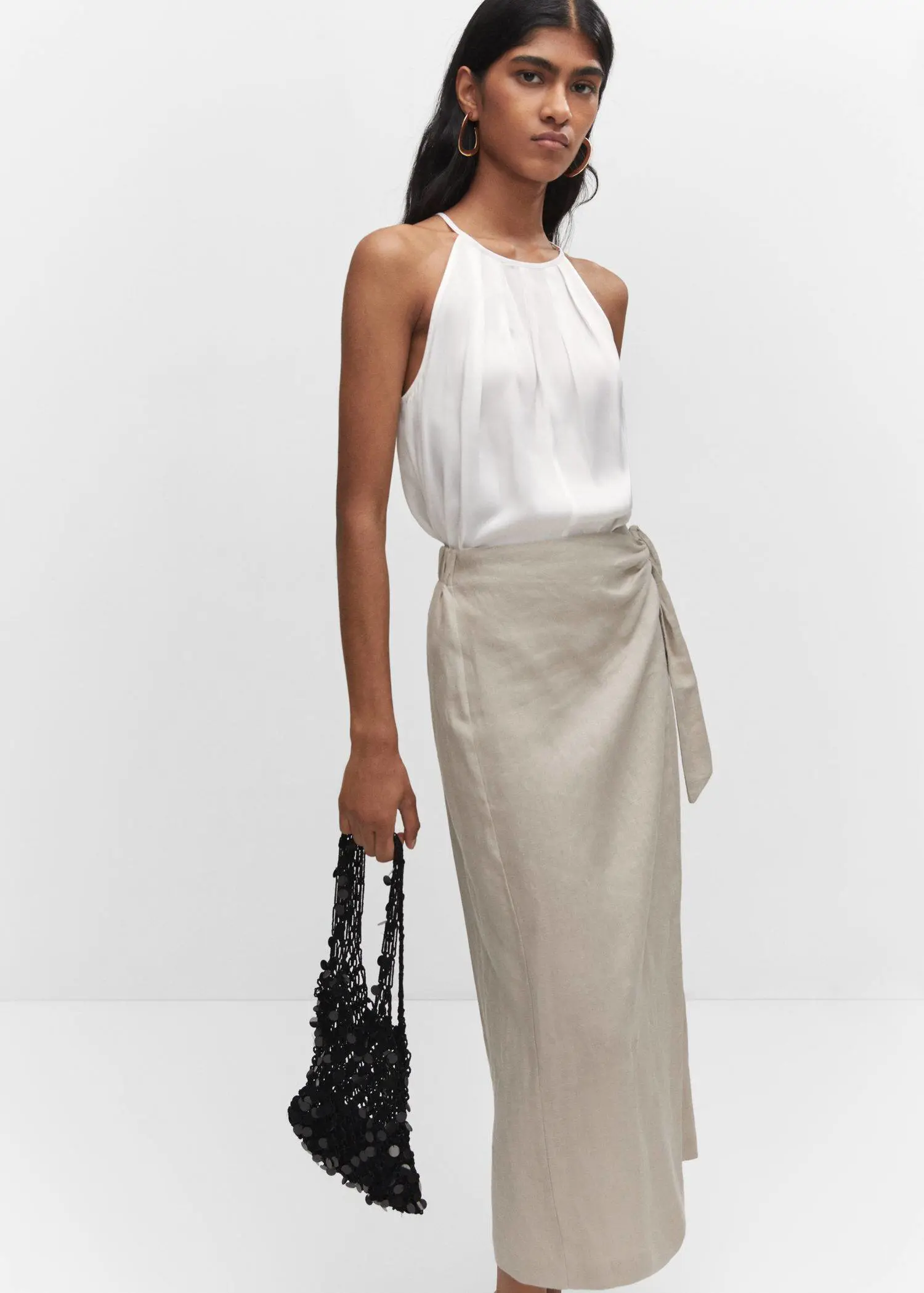 Mango Satin halter-neck top. a woman in a white top and a beige skirt. 
