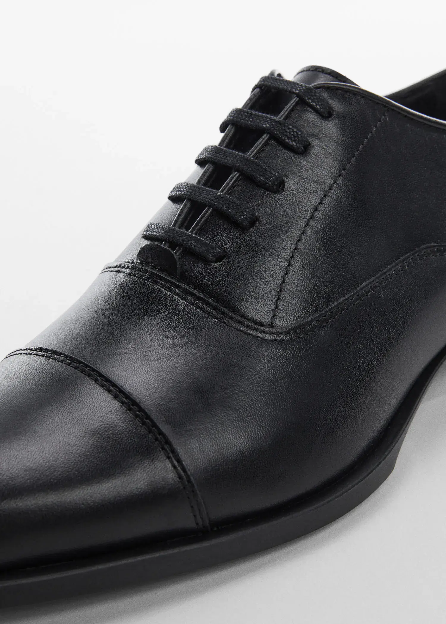 Mango Elongated leather suit shoes. a close-up view of a pair of black shoes. 