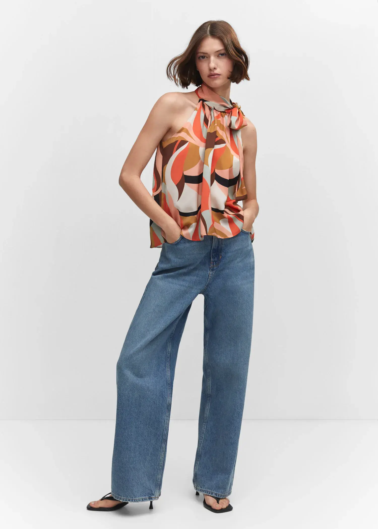 Mango Halter neck blouse with bow. a woman wearing a pair of wide leg jeans. 