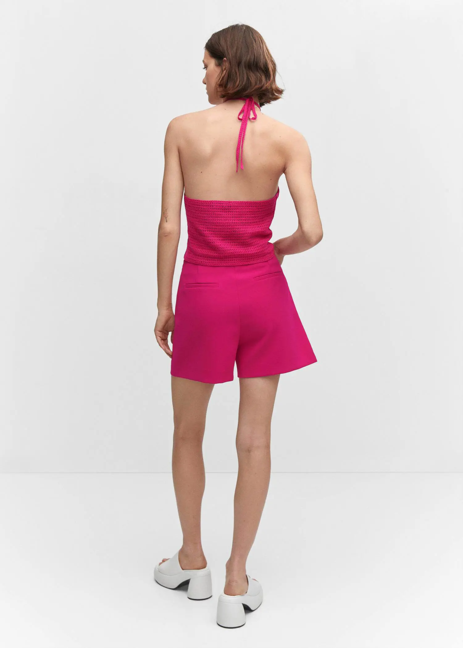 Mango High-waist straight shorts. a woman wearing a pink short and a halter top. 