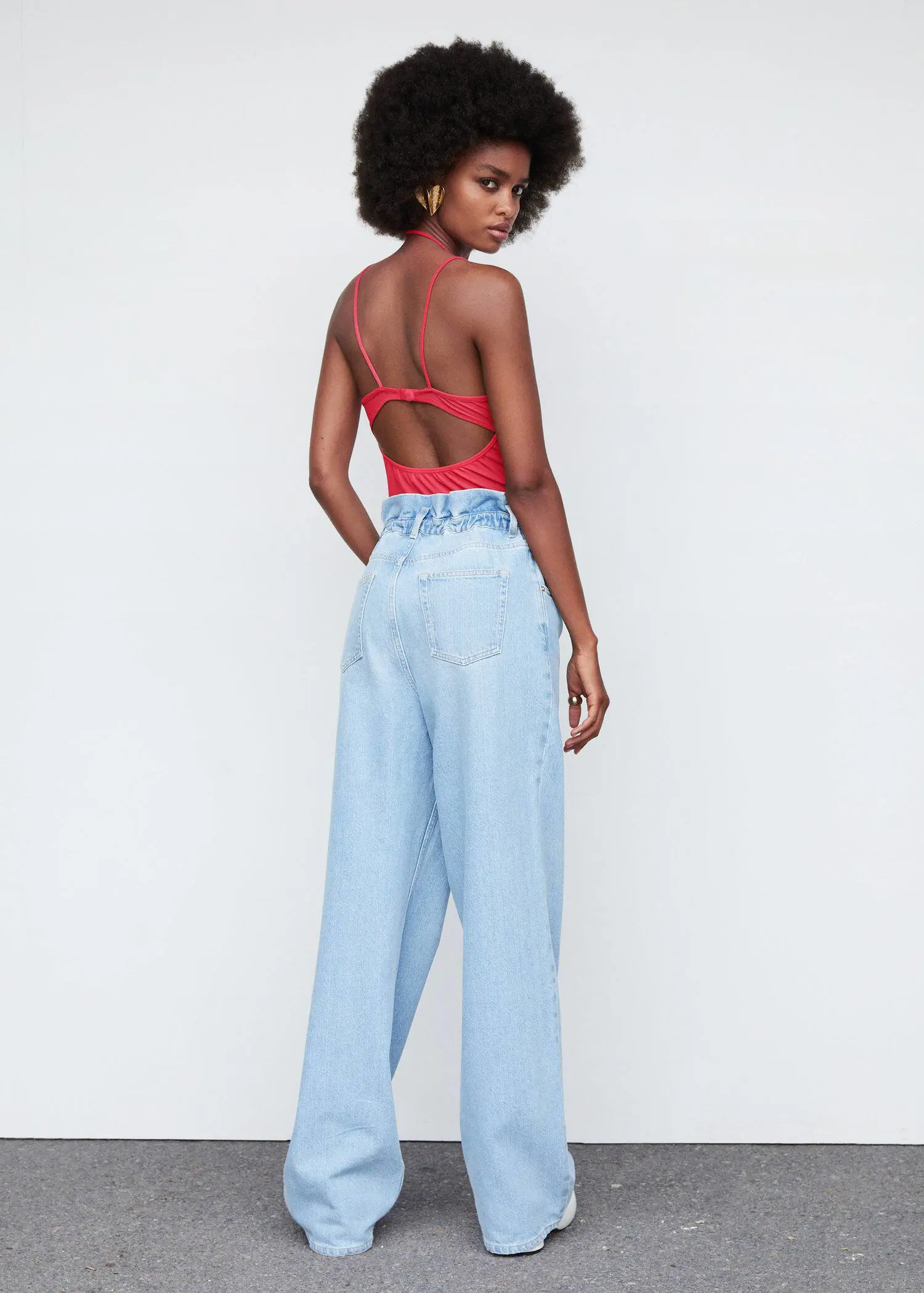Mango Double straps top. a woman in a red top and light blue pants. 