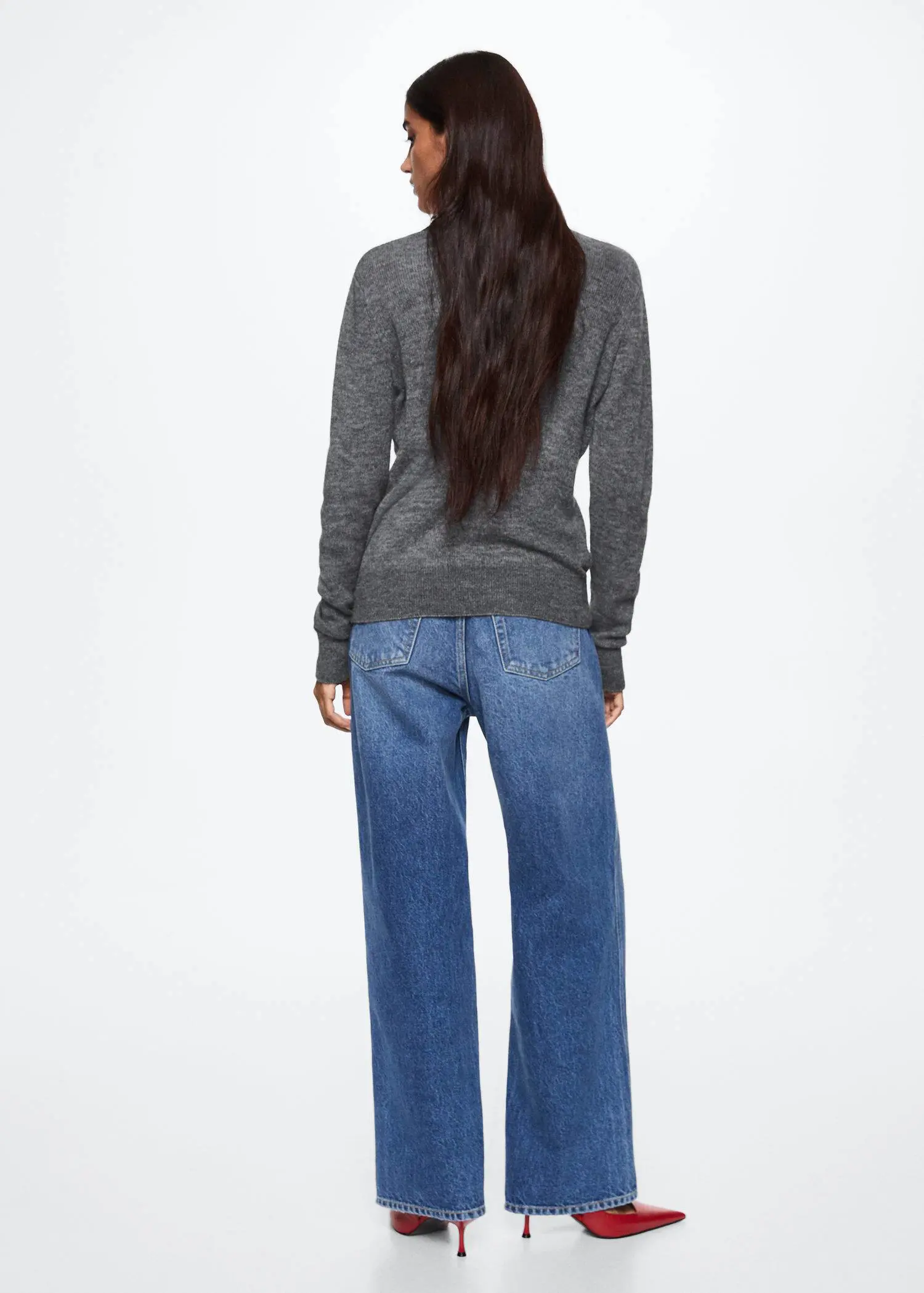 Mango Turtle neck sweater. a woman with long black hair standing in front of a white wall. 