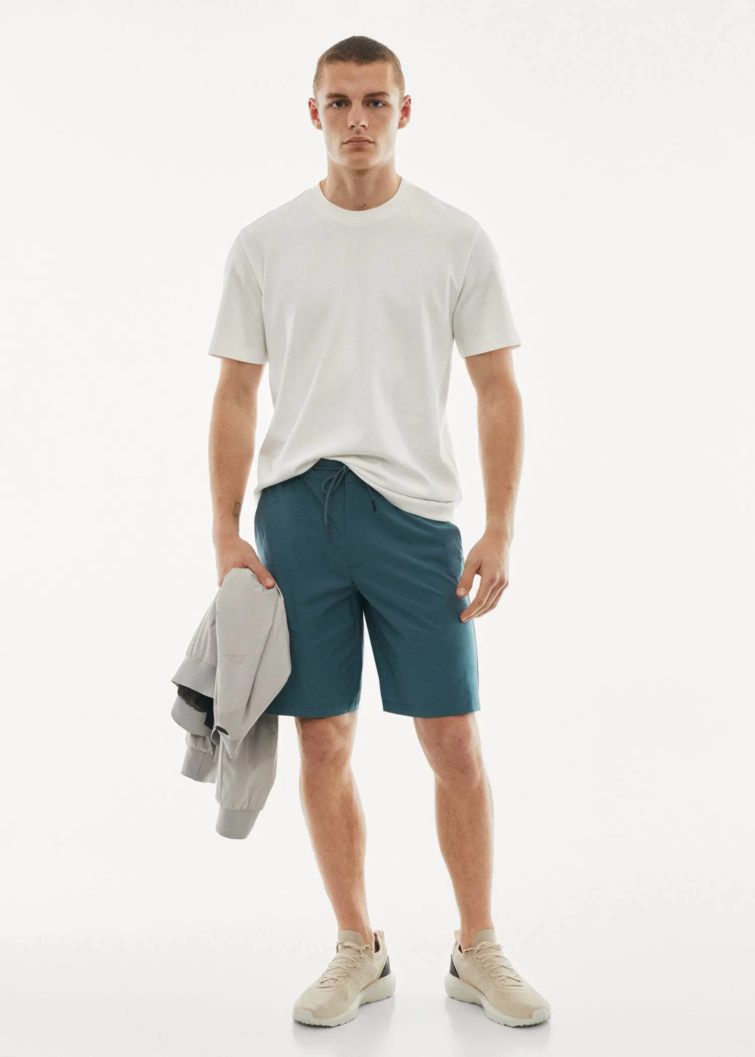Mango Water-repellent technical bermuda shorts. a young man in a white t-shirt is holding a towel. 