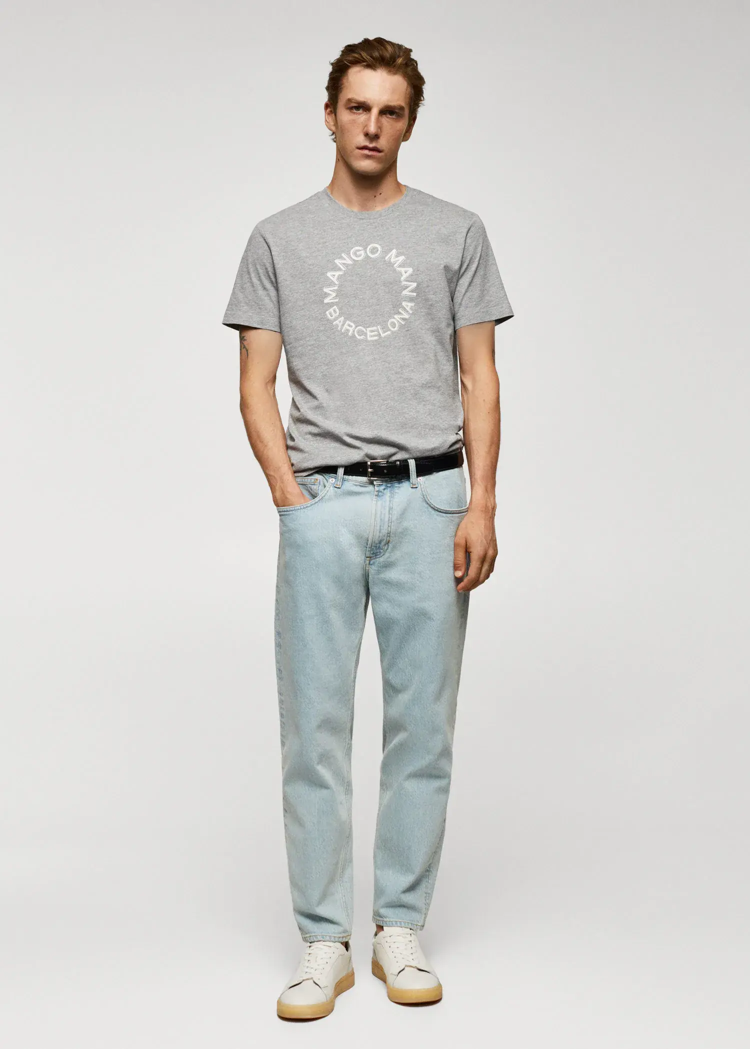 Mango 100% cotton t-shirt with logo. a man in a gray t-shirt and light blue pants. 
