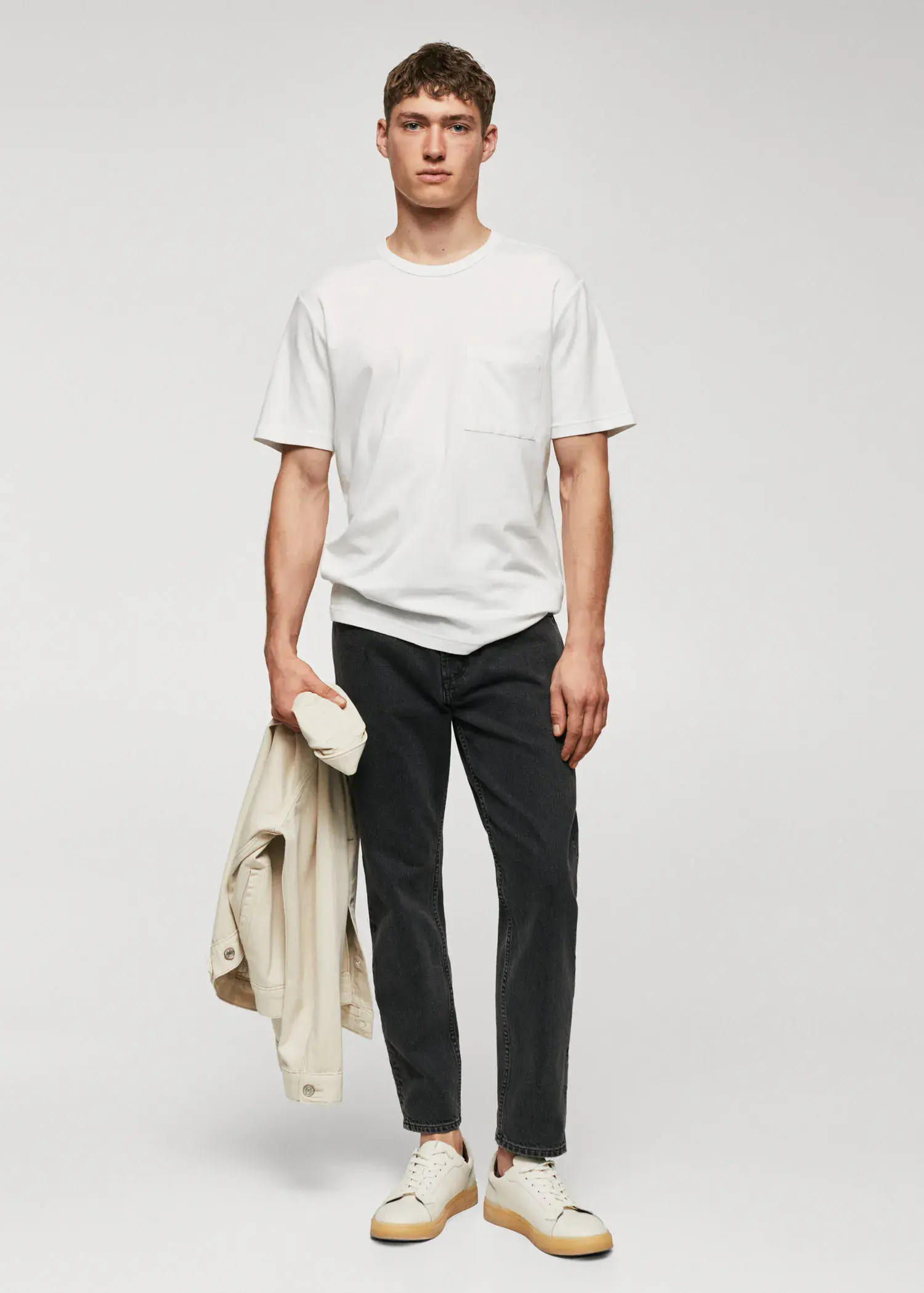 Mango 100% cotton t-shirt with pocket. a man in a white t-shirt is holding a jacket. 