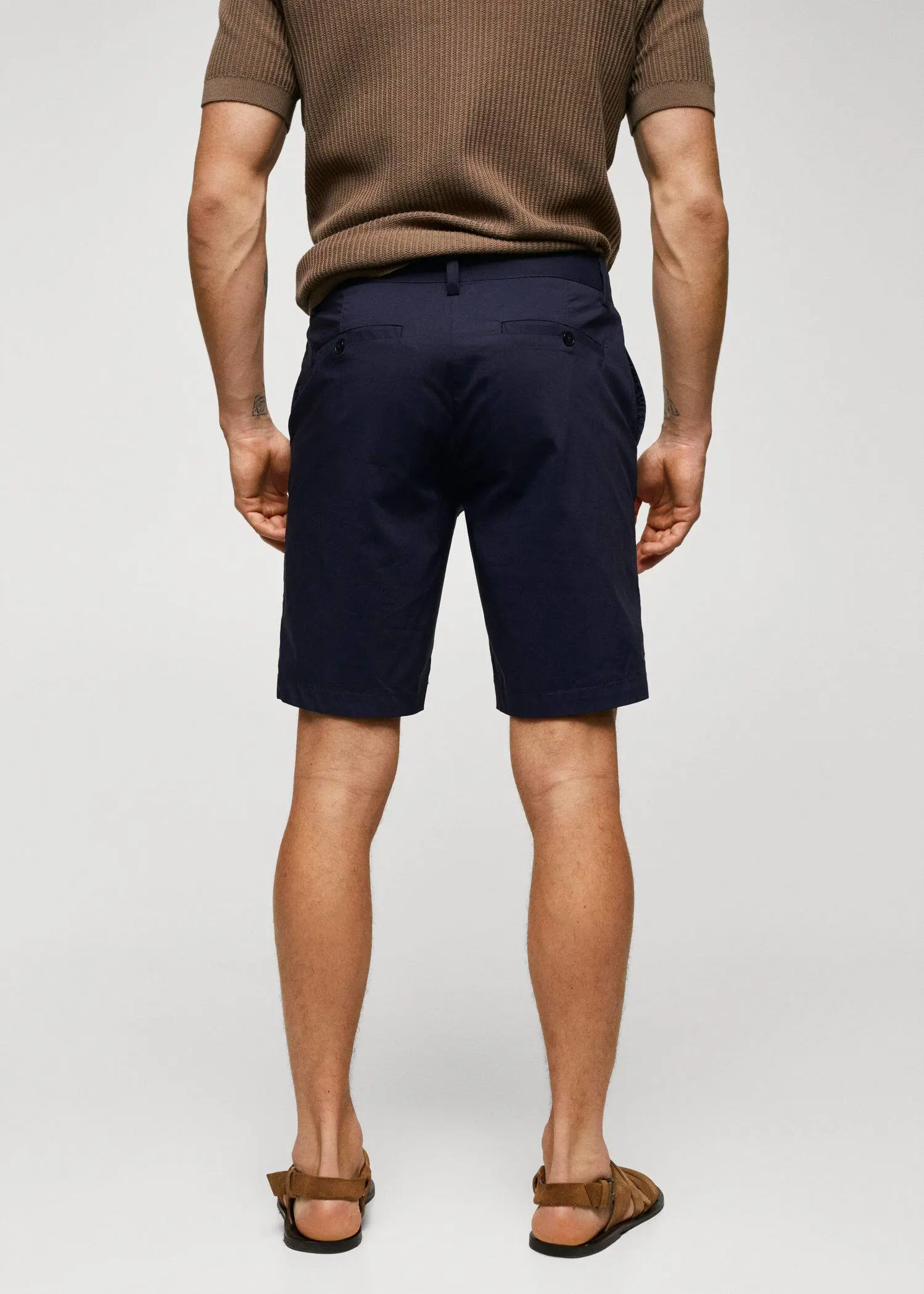 Mango Cotton pleated Bermuda shorts. a man wearing a pair of black shorts. 