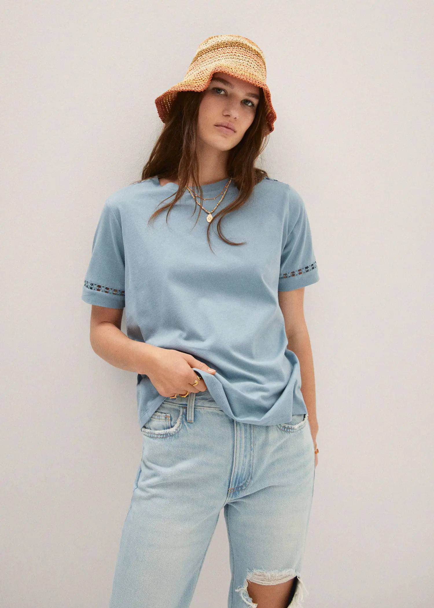 Mango Embroidered detail T-shirt. a woman wearing a red hat and a light blue t-shirt. 