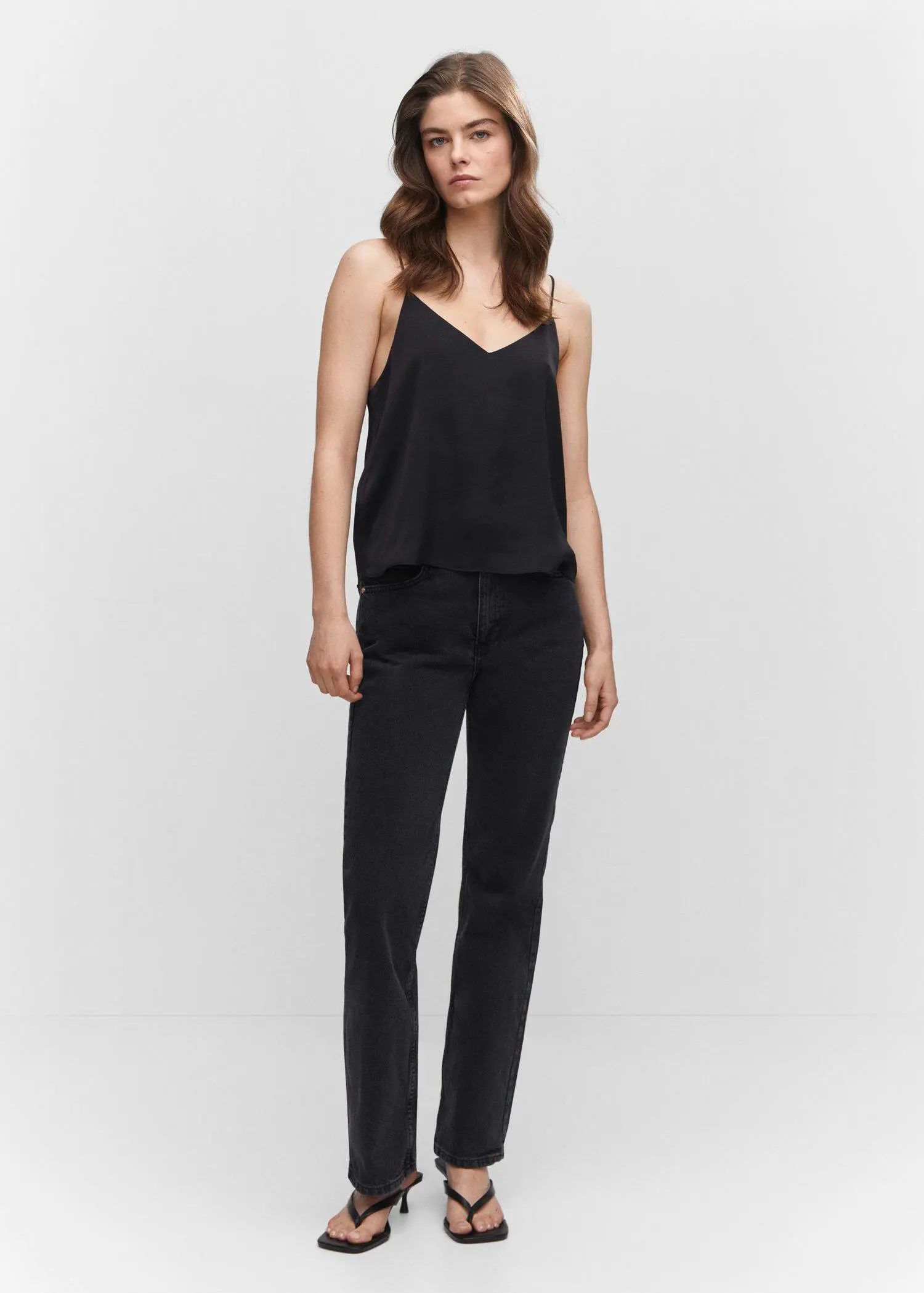 Mango Satin top with straps. a woman in a black outfit standing in front of a wall. 