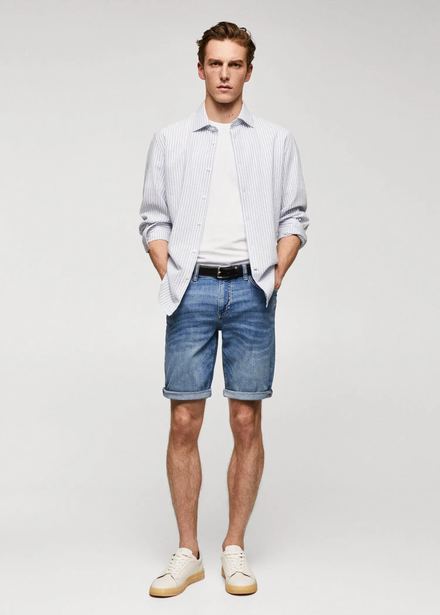 Mango Slim-fit denim bermuda shorts. a young man wearing a white shirt and blue shorts. 