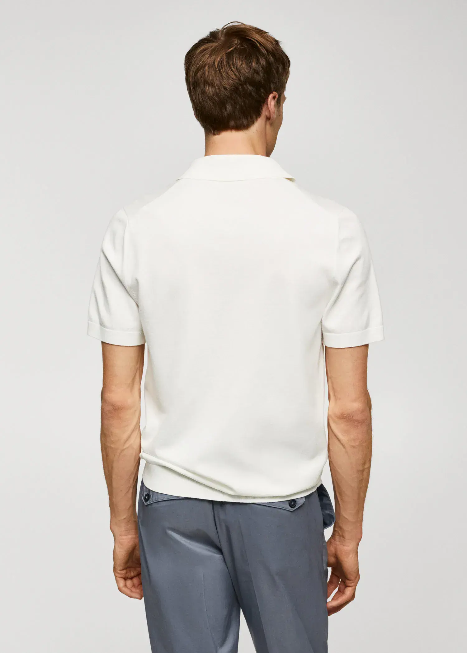 Mango Fine-knit polo shirt. a man in a white shirt is standing in front of a white wall. 