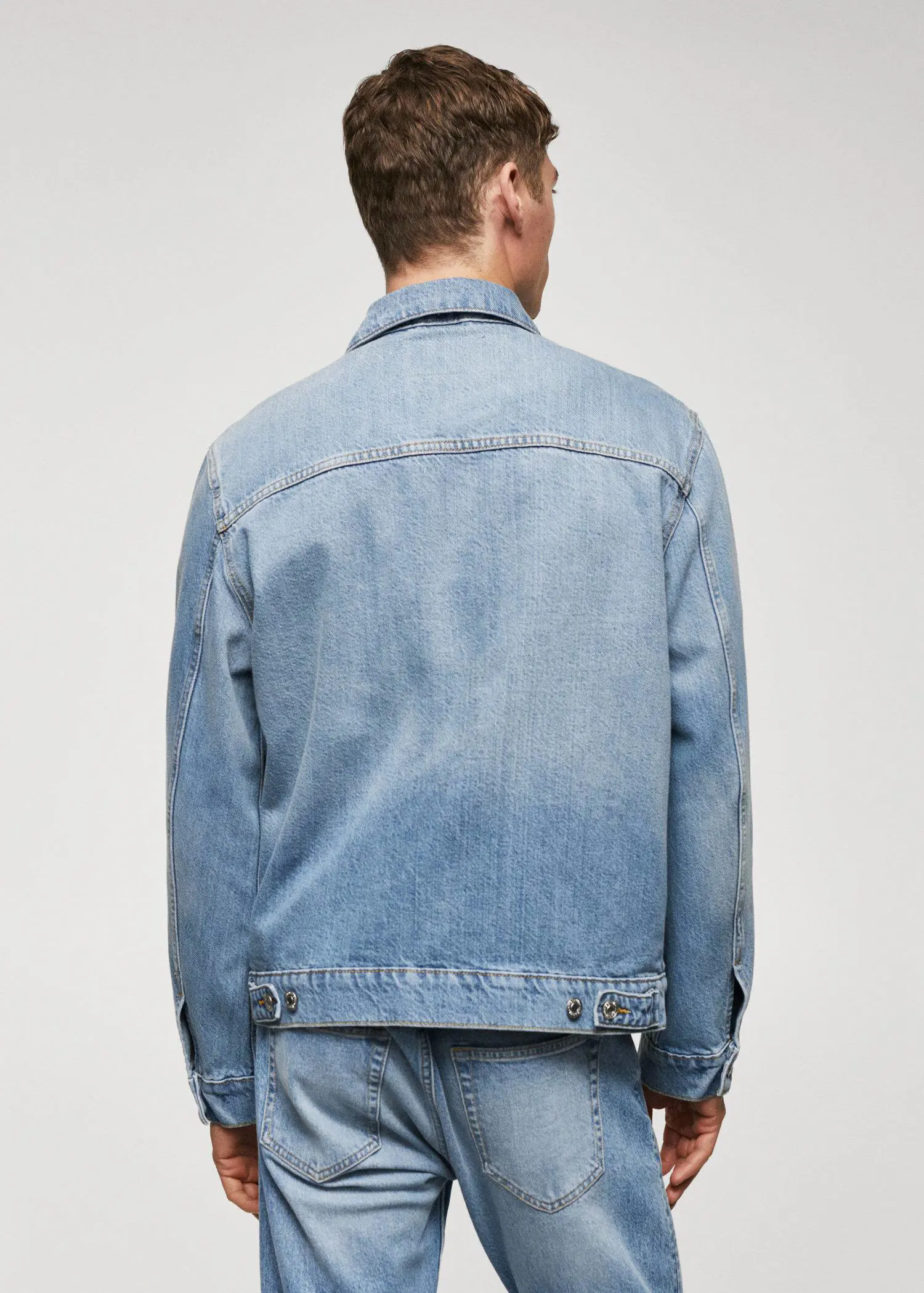 Mango Pocket denim overshirt. a man wearing a jean jacket is seen from the back. 