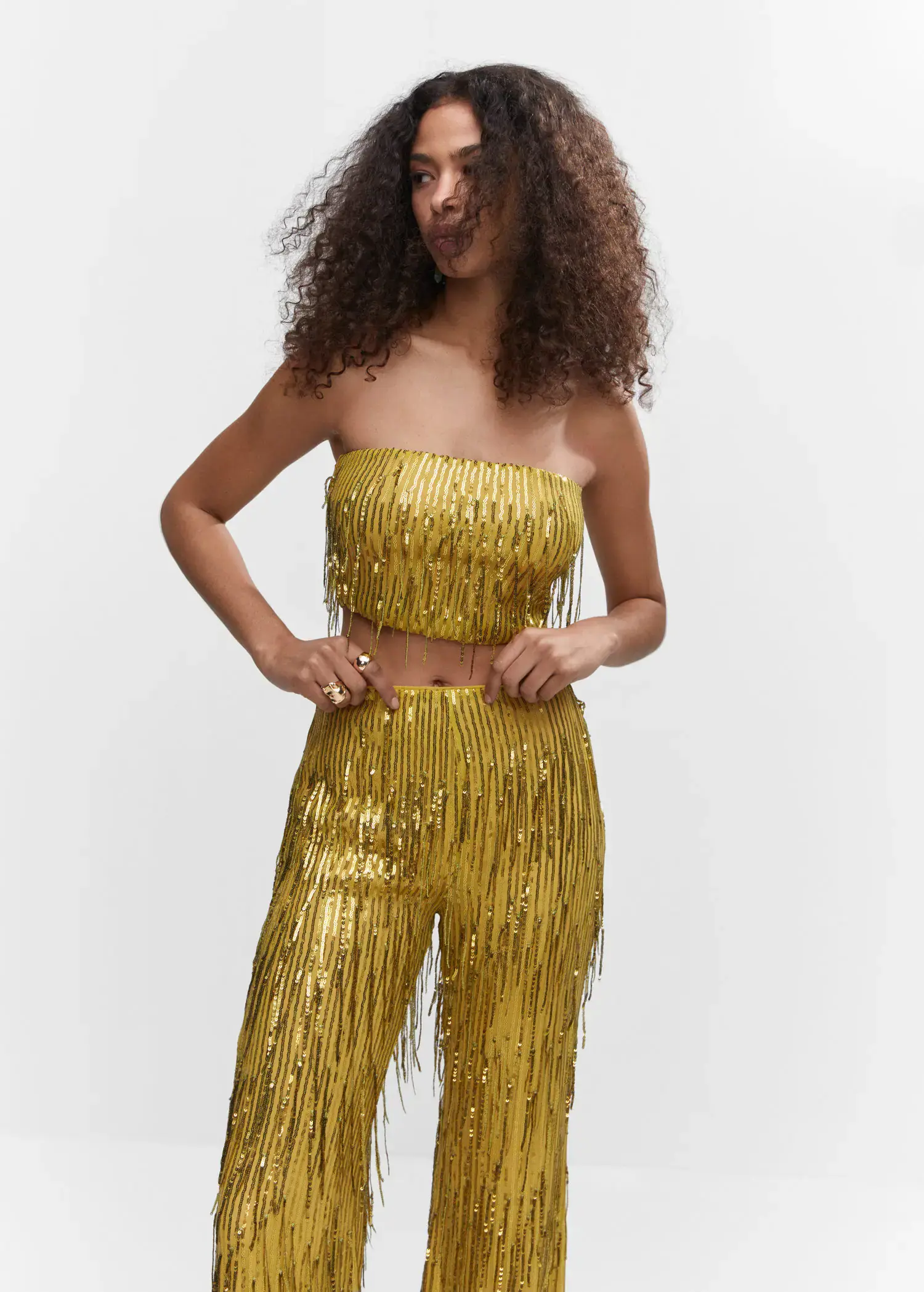 Mango Metallic fringed top. a woman in a gold outfit posing for a picture. 