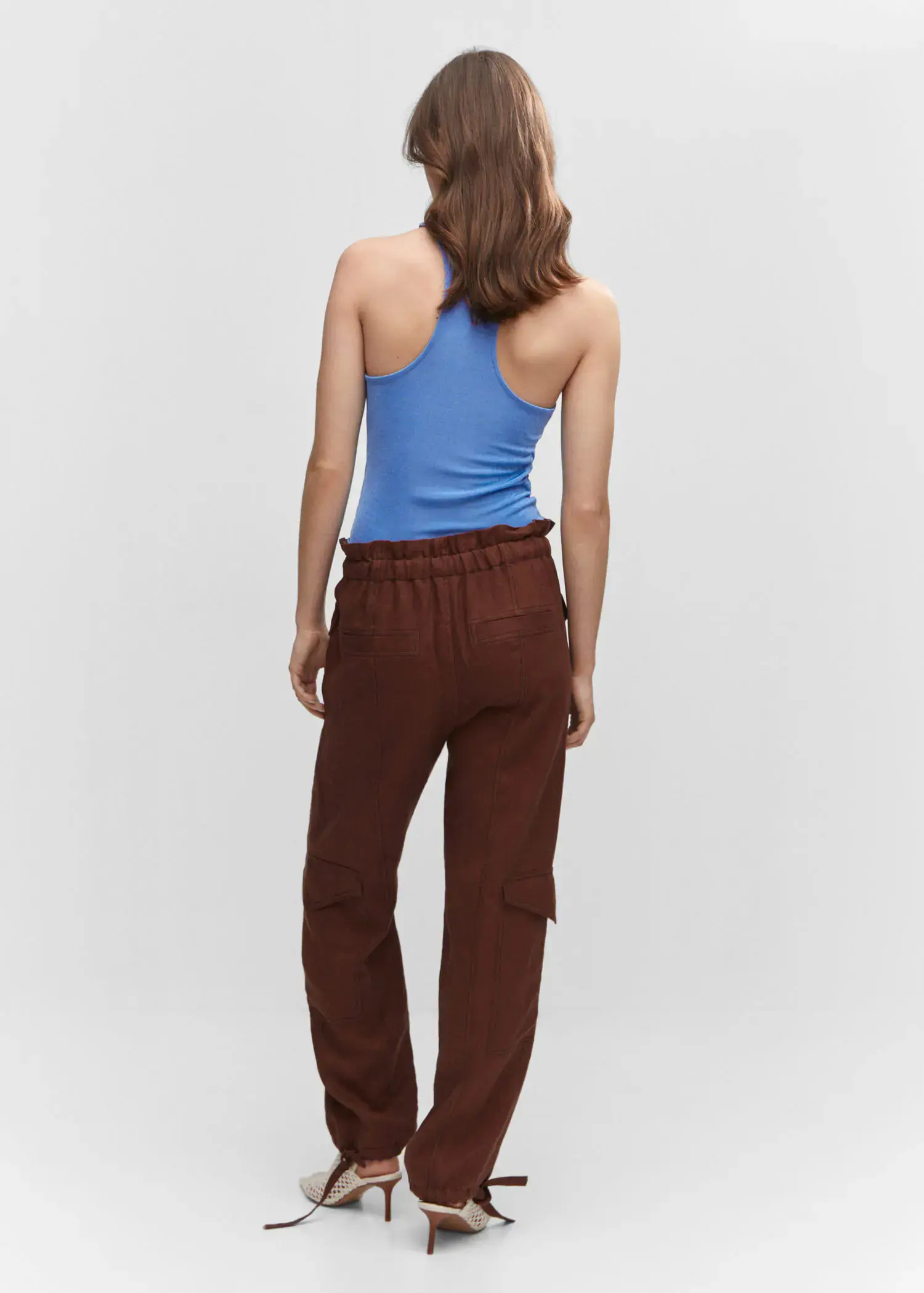 Mango Strap top. a woman wearing a blue tank top and brown pants. 