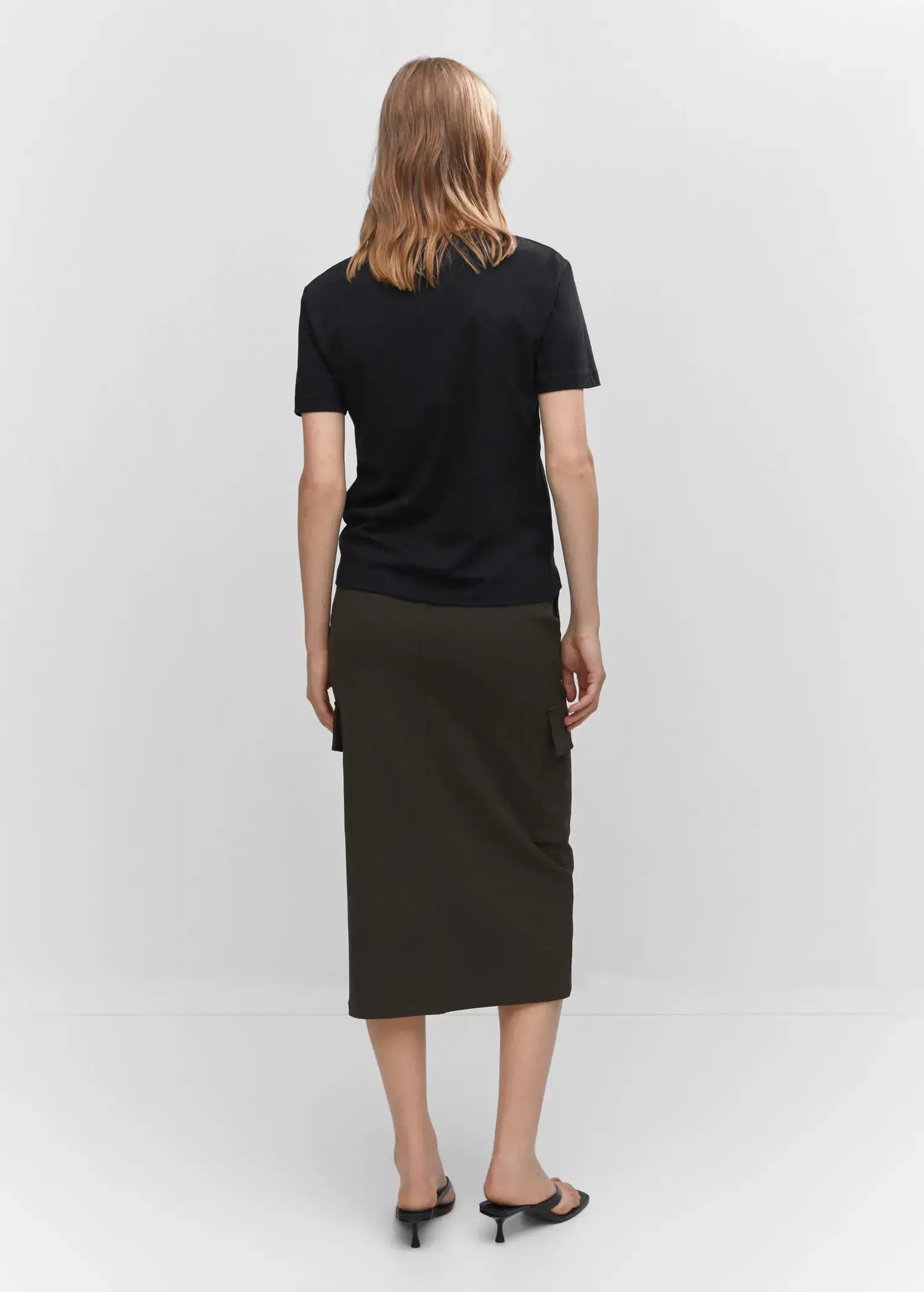 Mango V-neck cotton T-shirt. a person wearing a black shirt and a black skirt. 