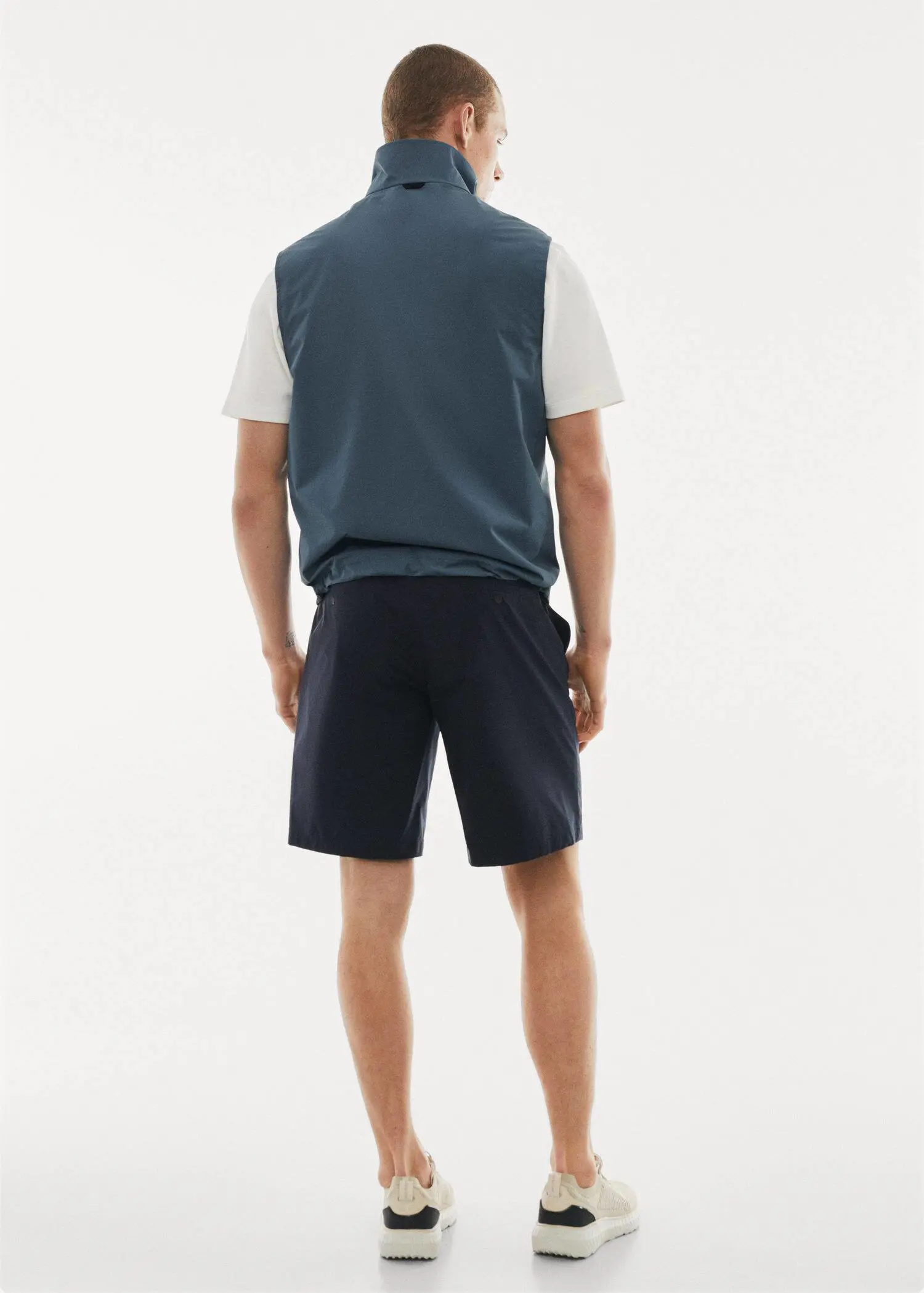 Mango Water-repellent technical gilet. a man wearing a blue vest and black shorts. 