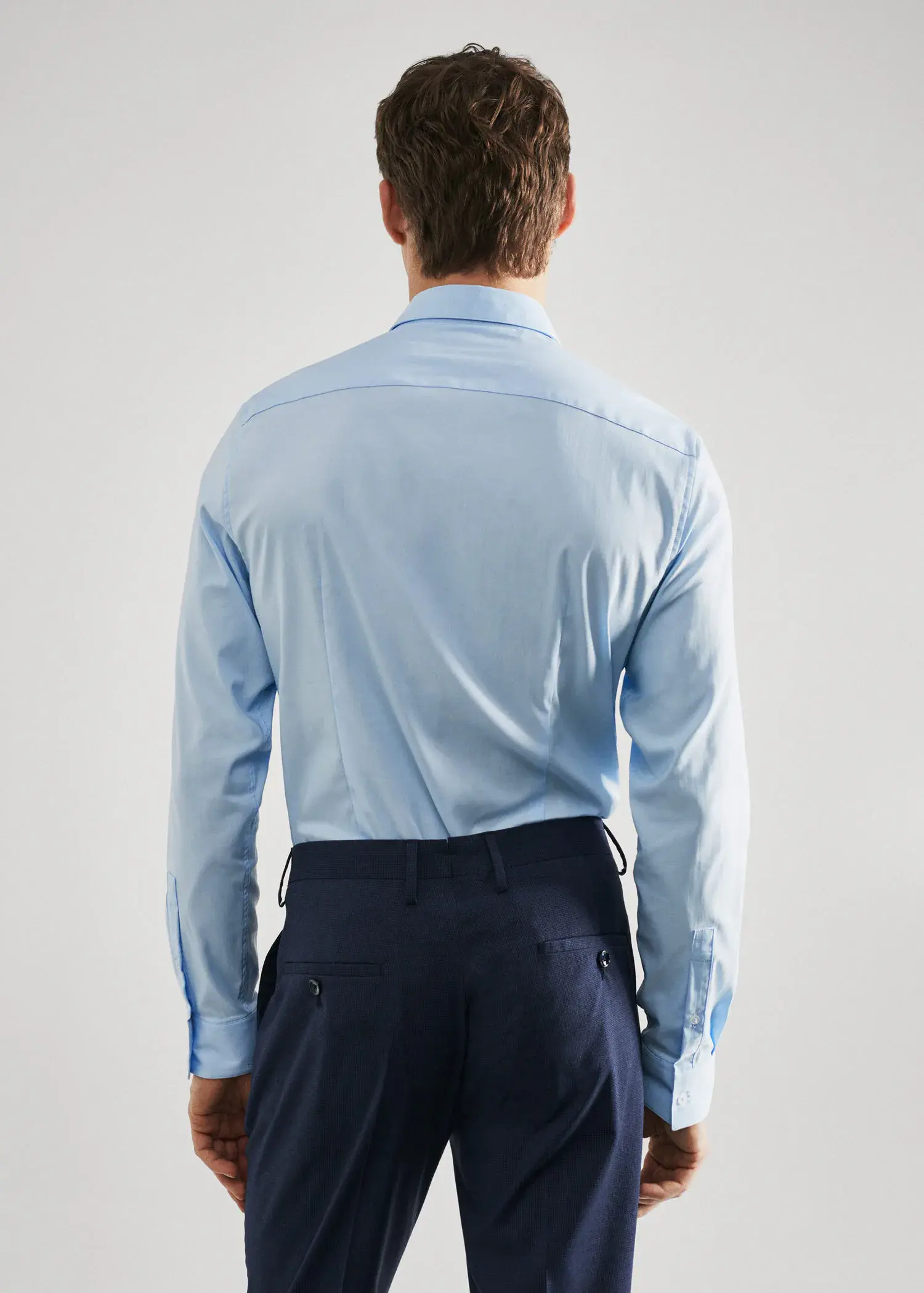 Mango Super slim-fit poplin suit shirt. a man wearing a blue shirt and blue pants. 
