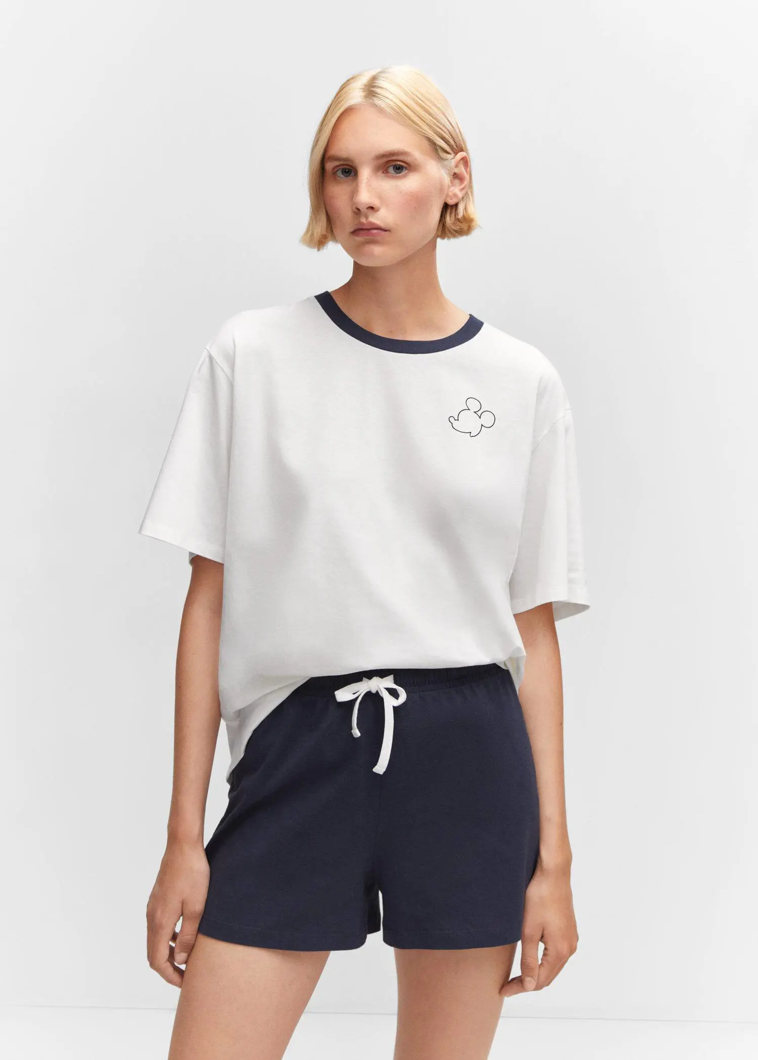 Mango Mickey Mouse cotton t-shirt. a woman wearing a white t-shirt and navy shorts. 