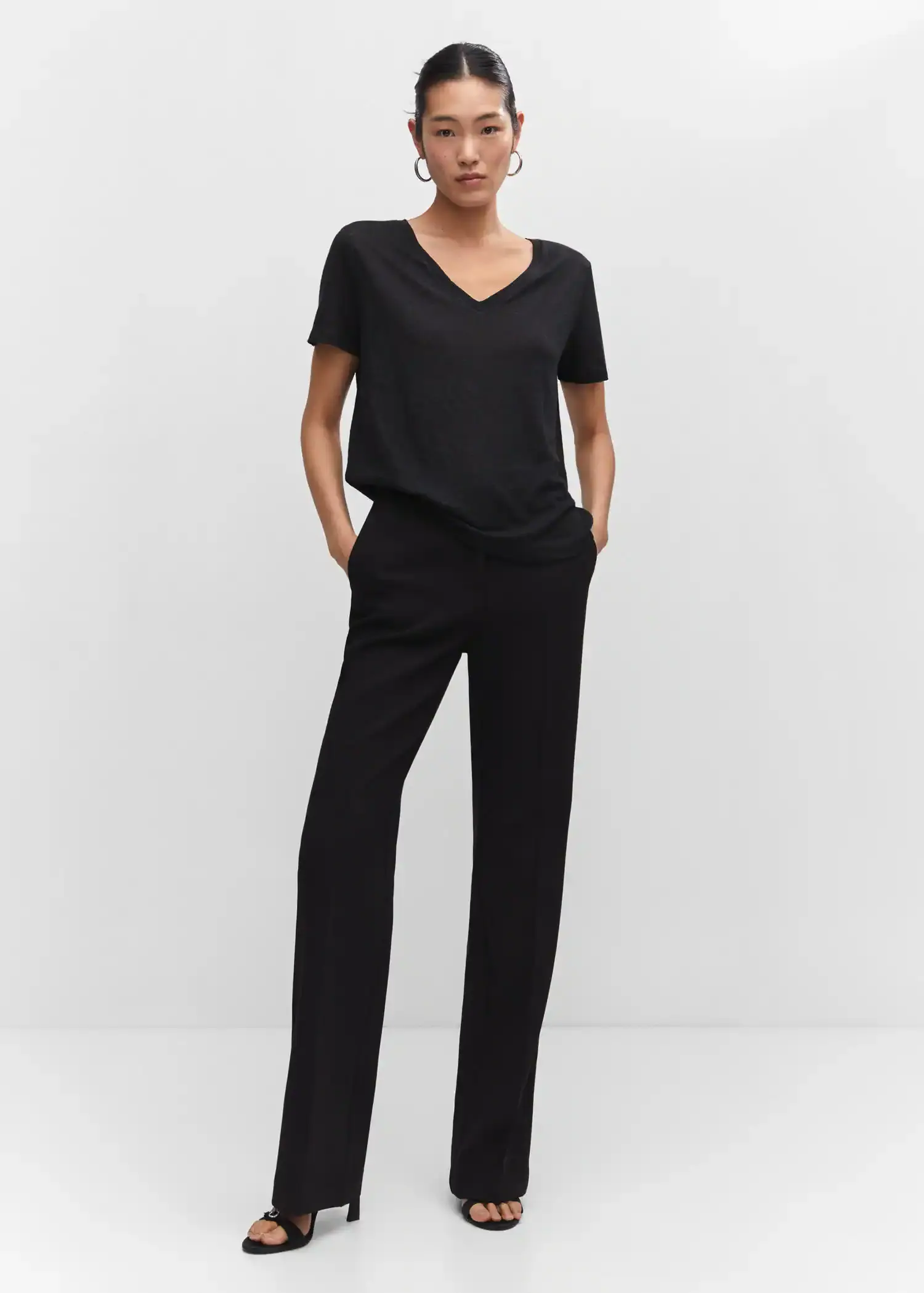 Mango V-neck linen t-shirt. a woman in a black outfit is posing for a picture 