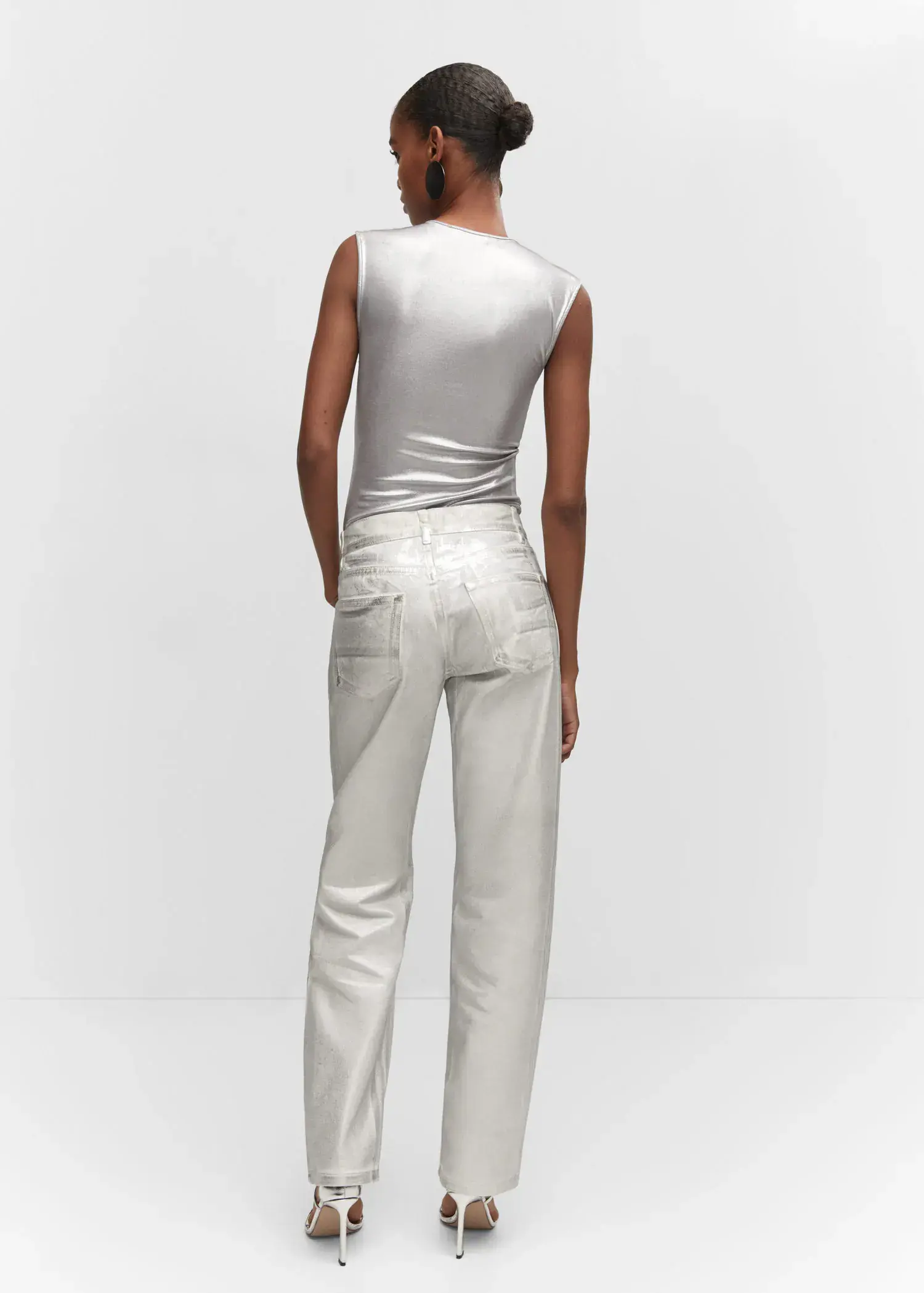 Mango Metallic bodysuit. a woman wearing a silver top and white pants. 