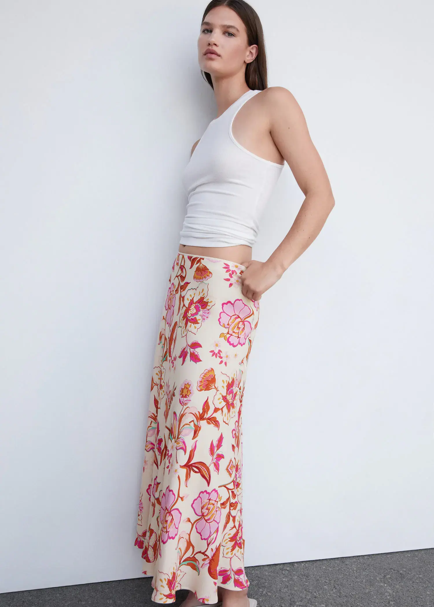 Mango Floral long skirt. a woman leaning against a wall with her hands in her pockets. 