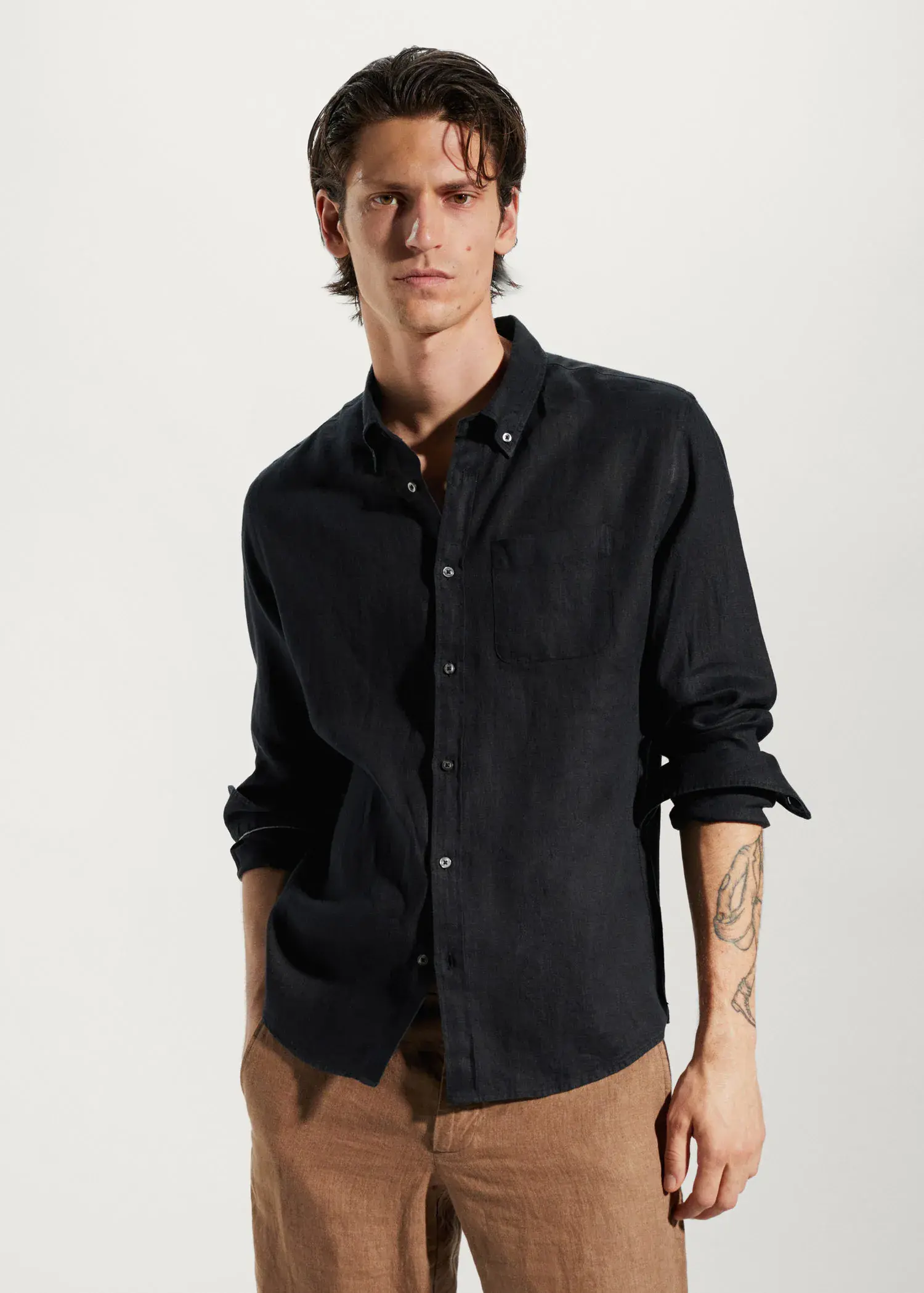Mango 100% linen slim-fit shirt. a young man wearing a black shirt and brown pants. 
