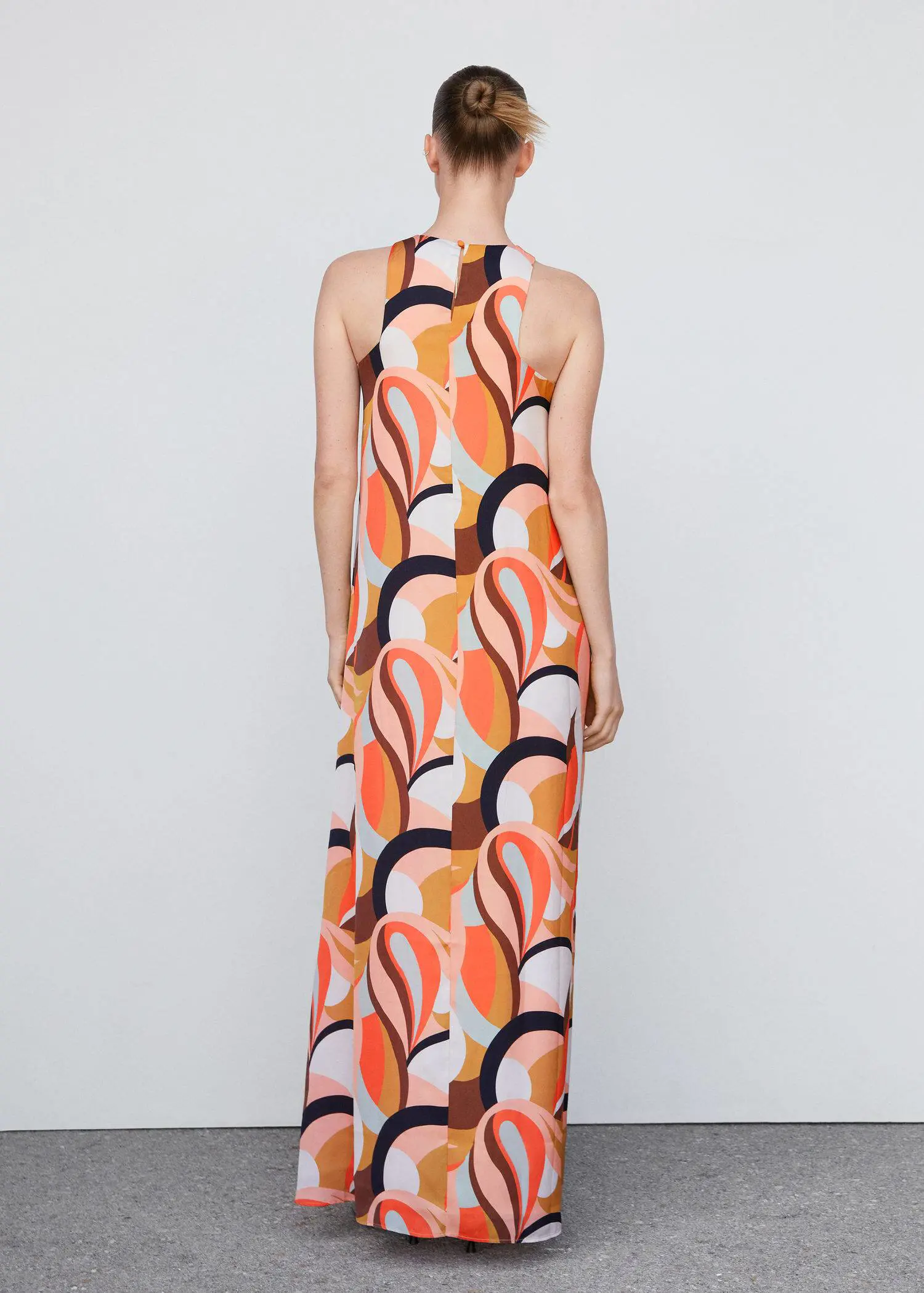 Mango Printed halter gown. a woman wearing a long orange and black dress. 