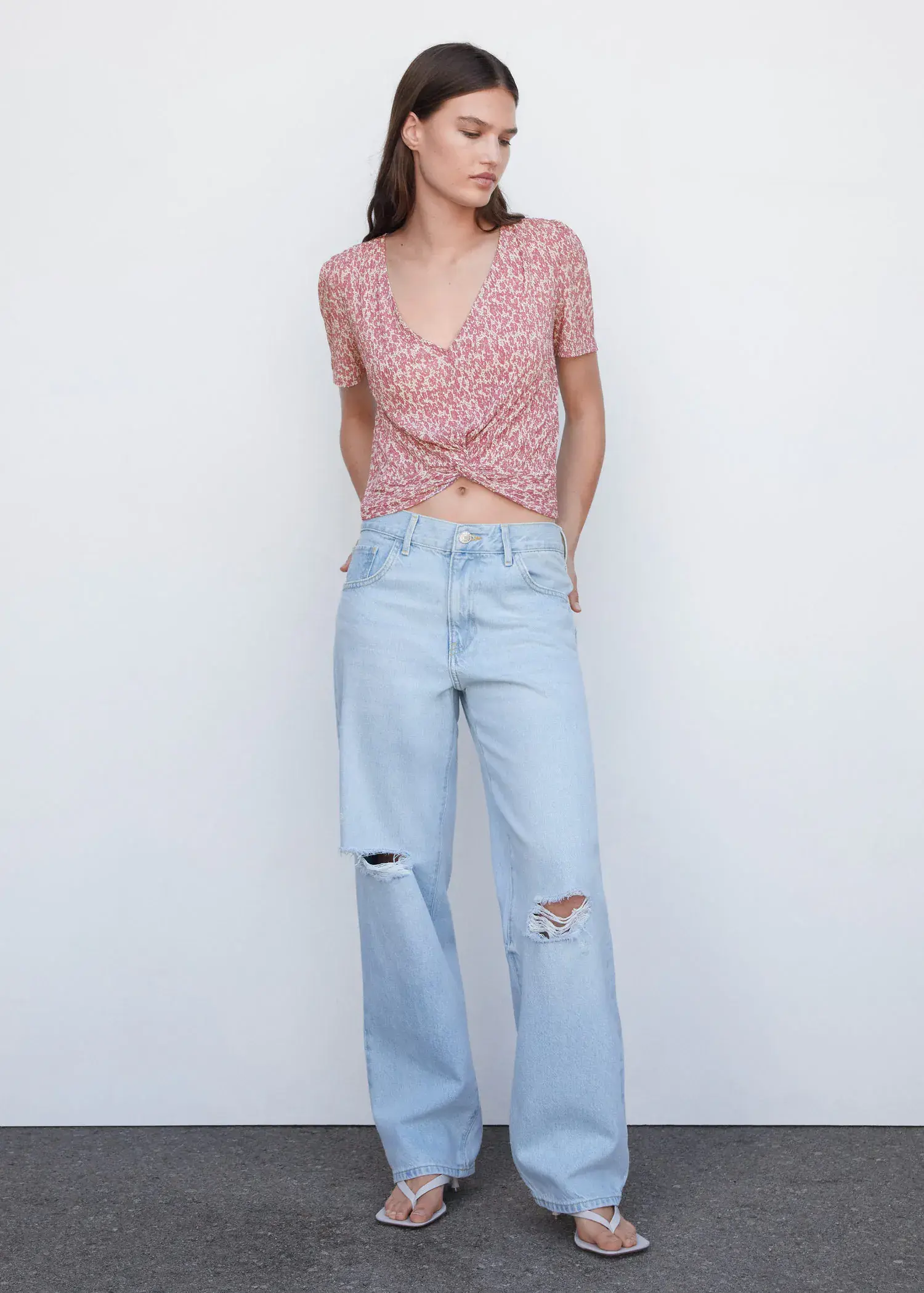 Mango Textured blouse with knot detail. a woman wearing ripped jeans and a pink top. 