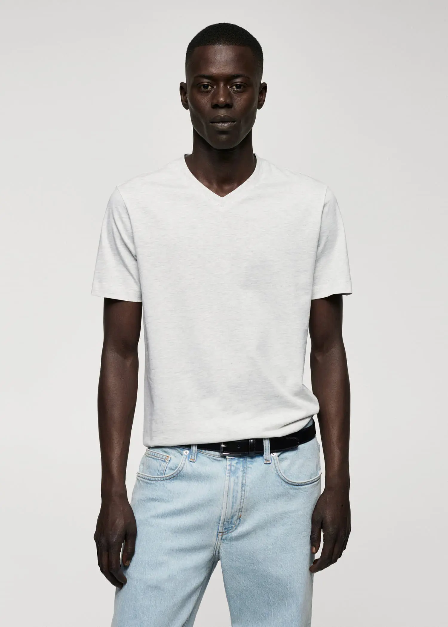 Mango Basic cotton V-neck T-shirt. a man in a white shirt and jeans. 