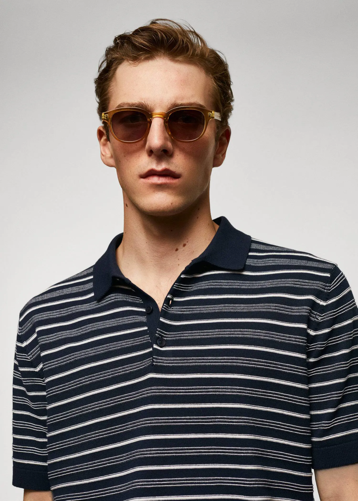 Mango Striped fine-knit polo shirt. a young man wearing sunglasses and a striped shirt. 