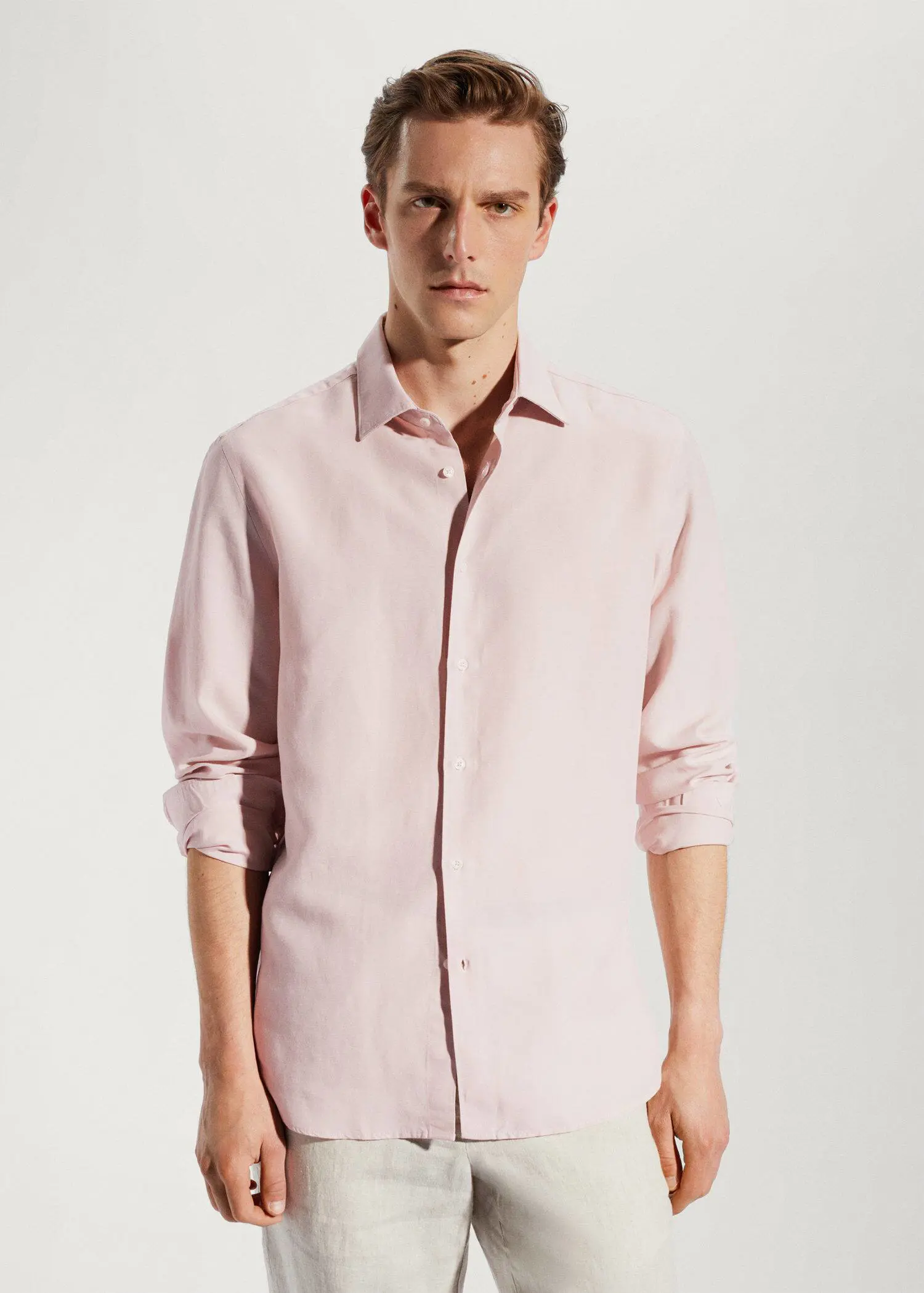 Mango Light tencel-linen shirt. a man in a pink shirt is posing for a picture. 