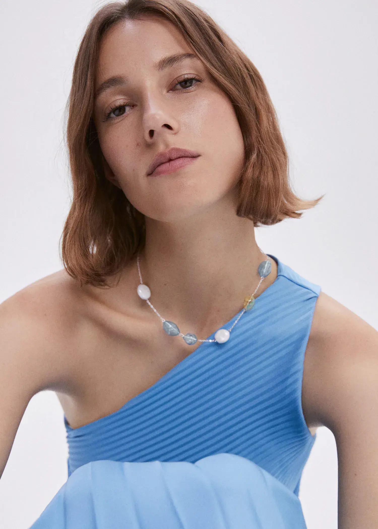 Mango Crystal bead necklace. a woman wearing a blue dress and a necklace. 