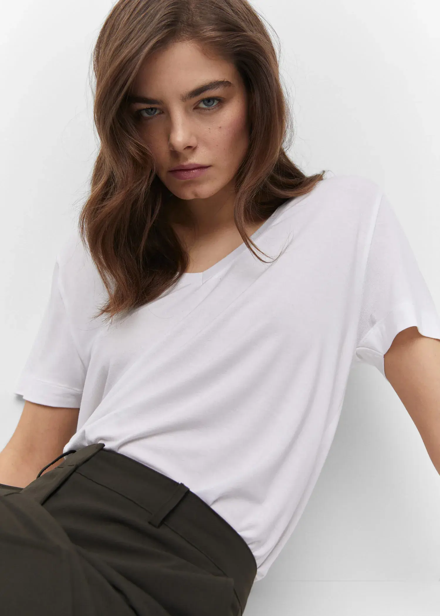 Mango V-neck T-shirt. a woman wearing a white shirt and black pants. 