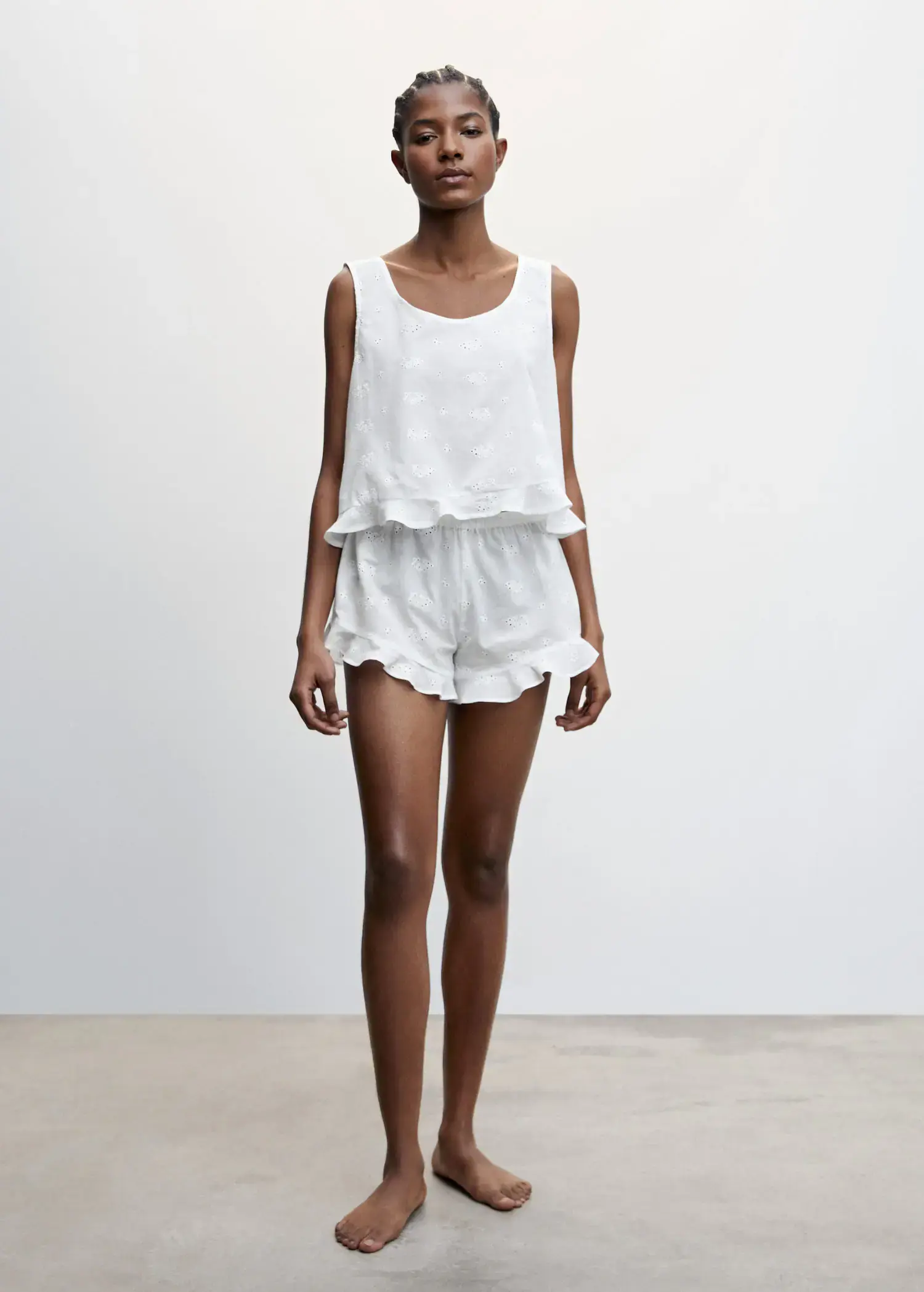 Mango Pyjama top with openwork details. a woman standing in a room wearing white shorts and a top. 