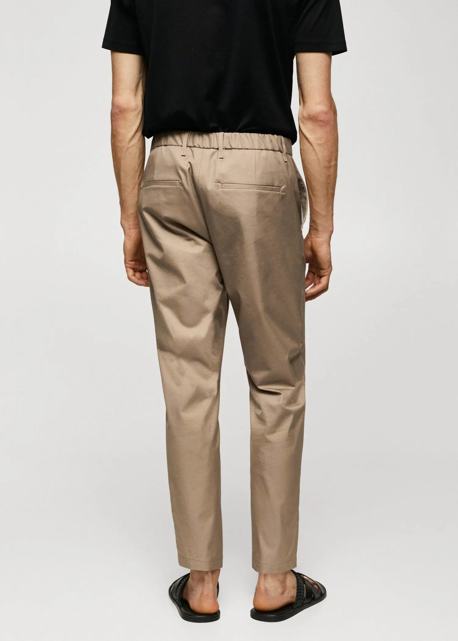 Mango Slim-fit cotton pants. a man wearing a black shirt and beige pants. 
