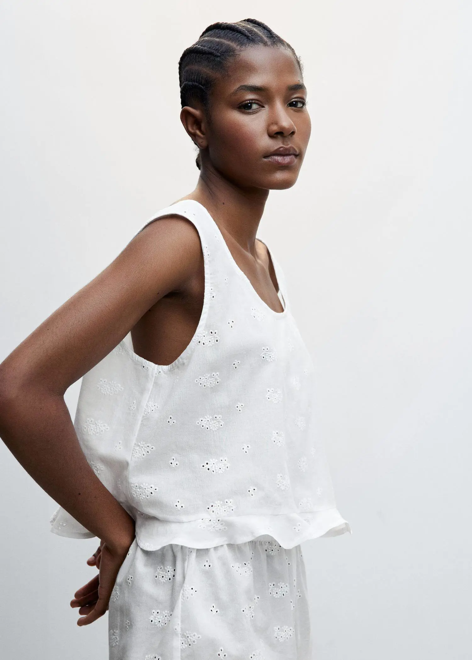 Mango Pyjama top with openwork details. a woman wearing a white top and white shorts. 