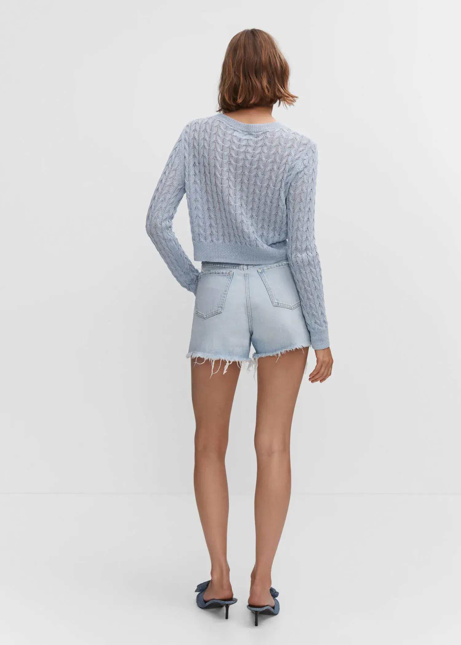 Mango Straight shorts with frayed hem. a woman wearing a blue sweater and denim shorts. 