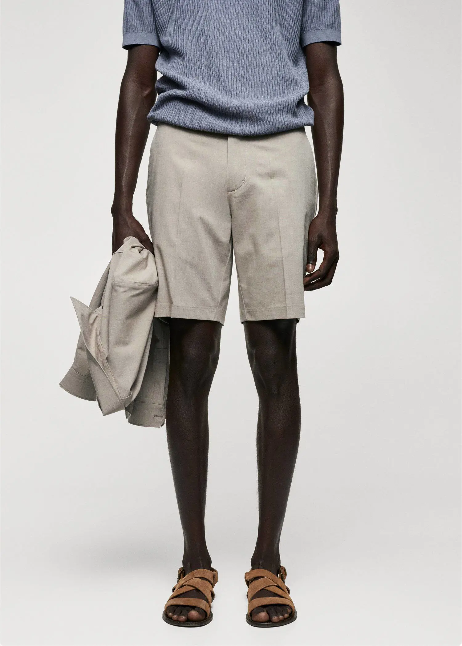 Mango Slim-fit bermuda shorts with adjustable waist. a man in shorts holding a jacket in front of him. 