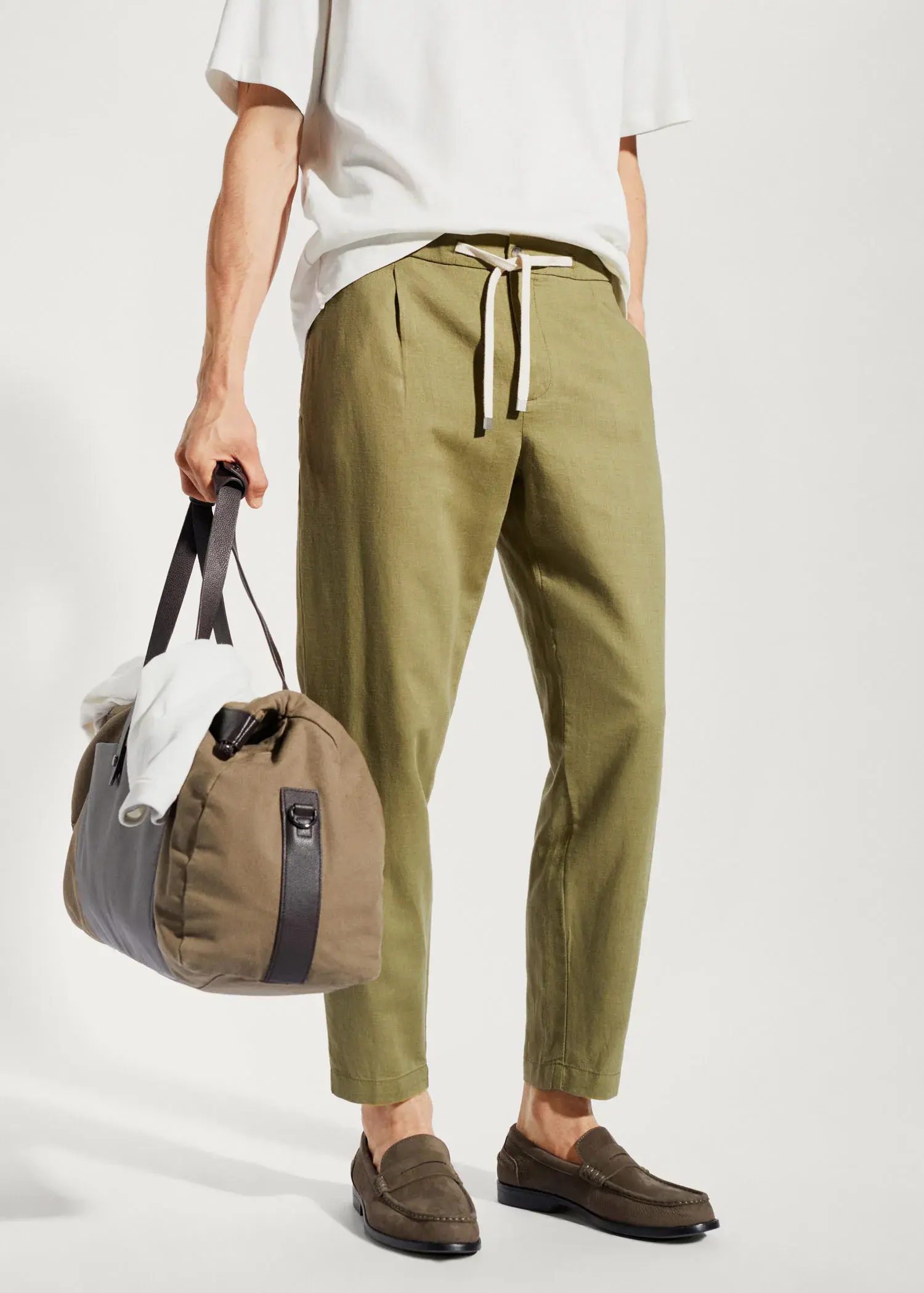 Mango Slim-fit pants with drawstring . a person holding a duffel bag while wearing green pants. 