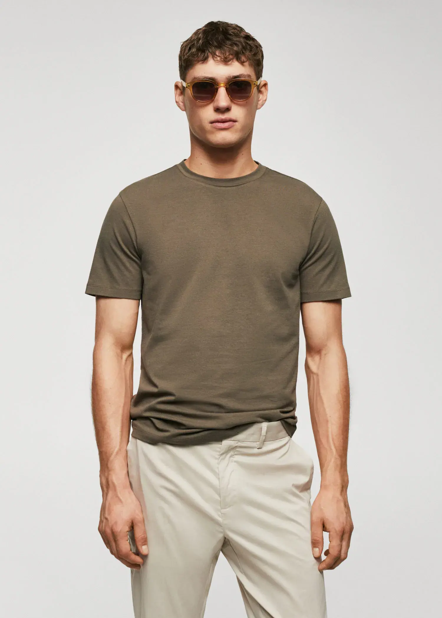 Mango Stretch cotton T-shirt. a man wearing sunglasses standing in front of a white wall. 
