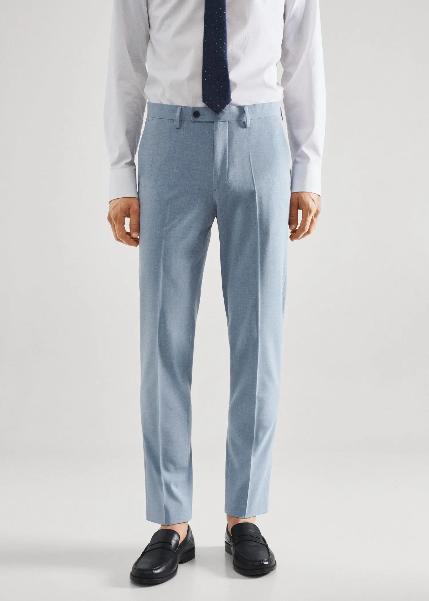 Mango Stretch fabric slim-fit suit trousers. a man wearing a suit and tie standing in front of a white wall. 