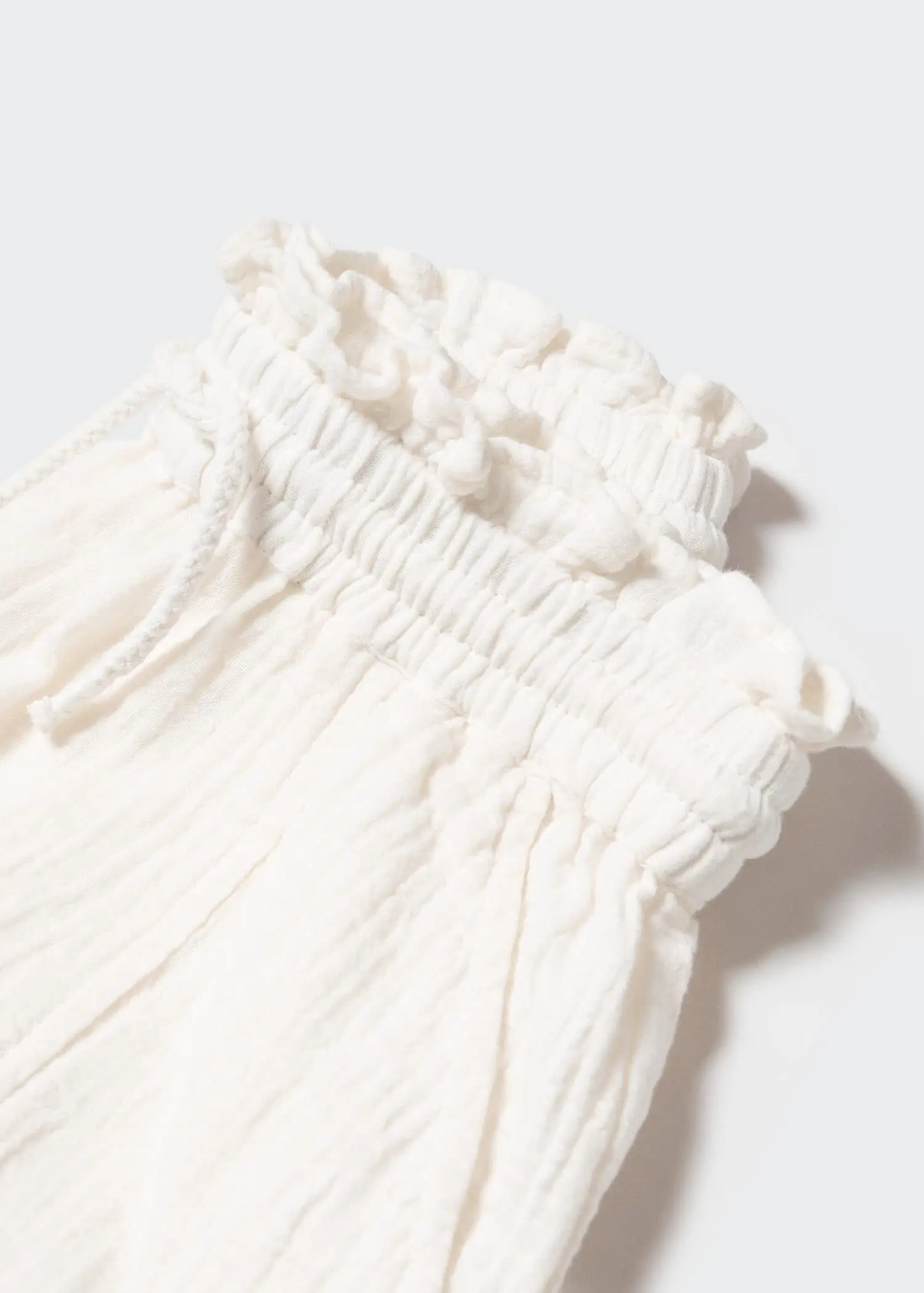 Mango Shorts with gathered detail . a close-up view of the top of a white dress. 