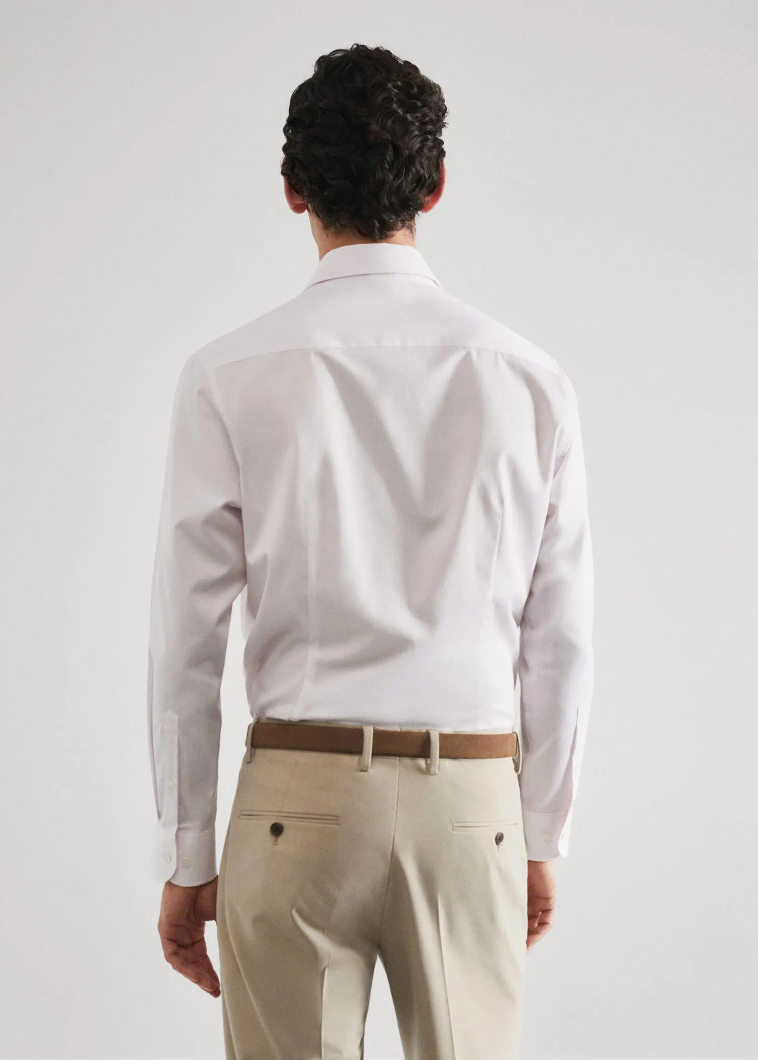 Mango Slim-fit micro-stripe twill suit shirt. a man in a white shirt and beige pants. 