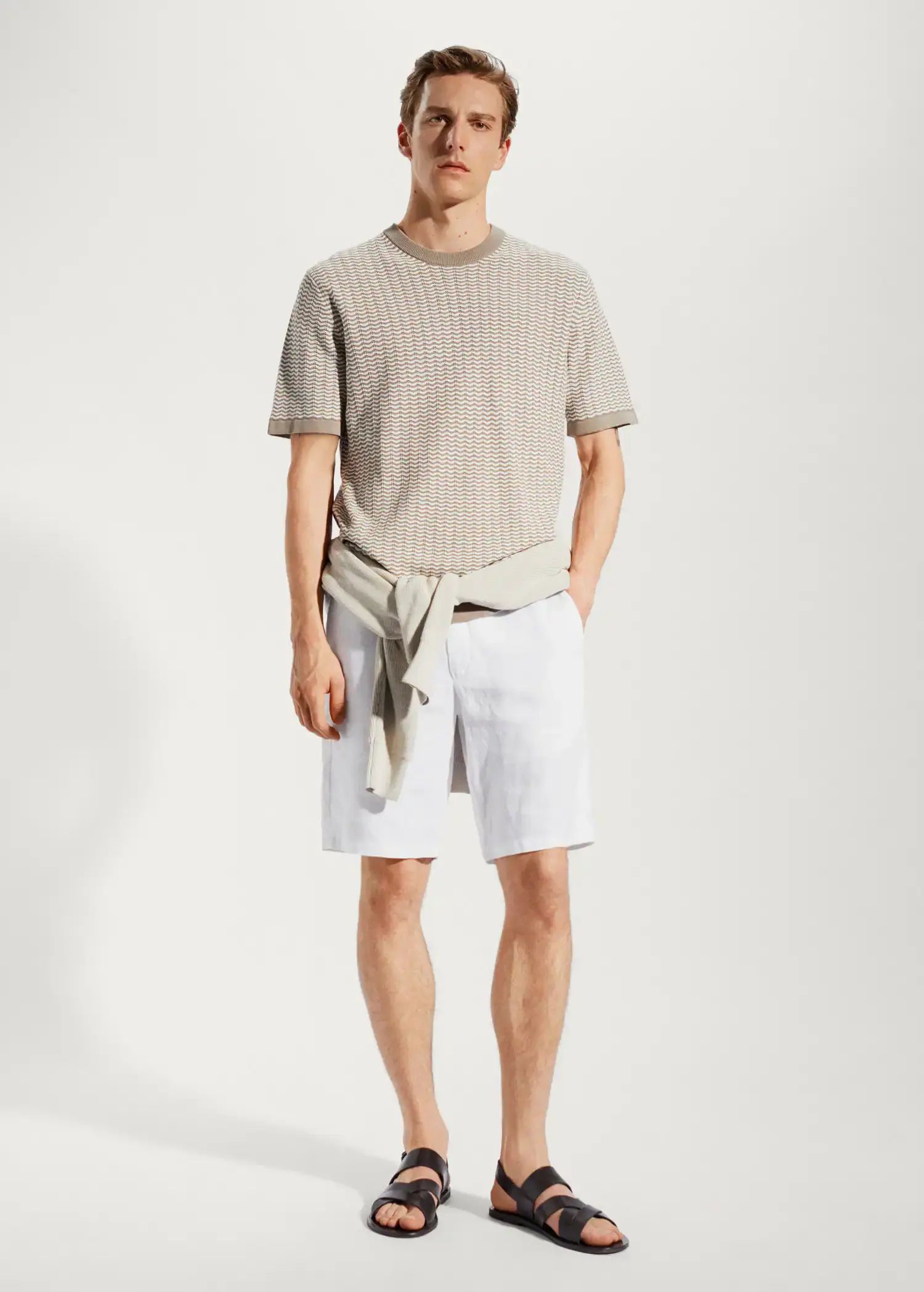 Mango 100% linen shorts. a man in a tan shirt and white shorts. 