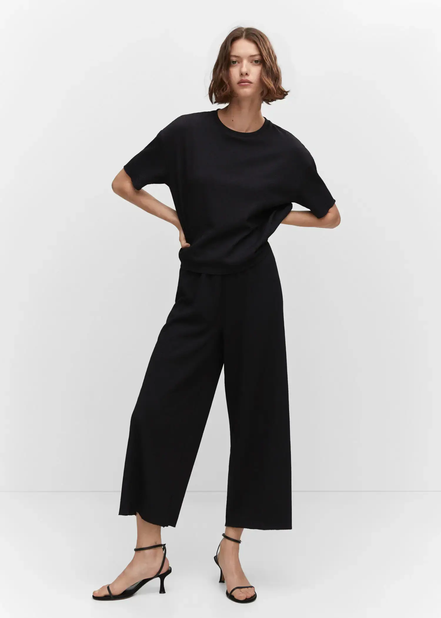 Mango Oversized textured t-shirt. a woman in black shirt and pants posing for a picture 