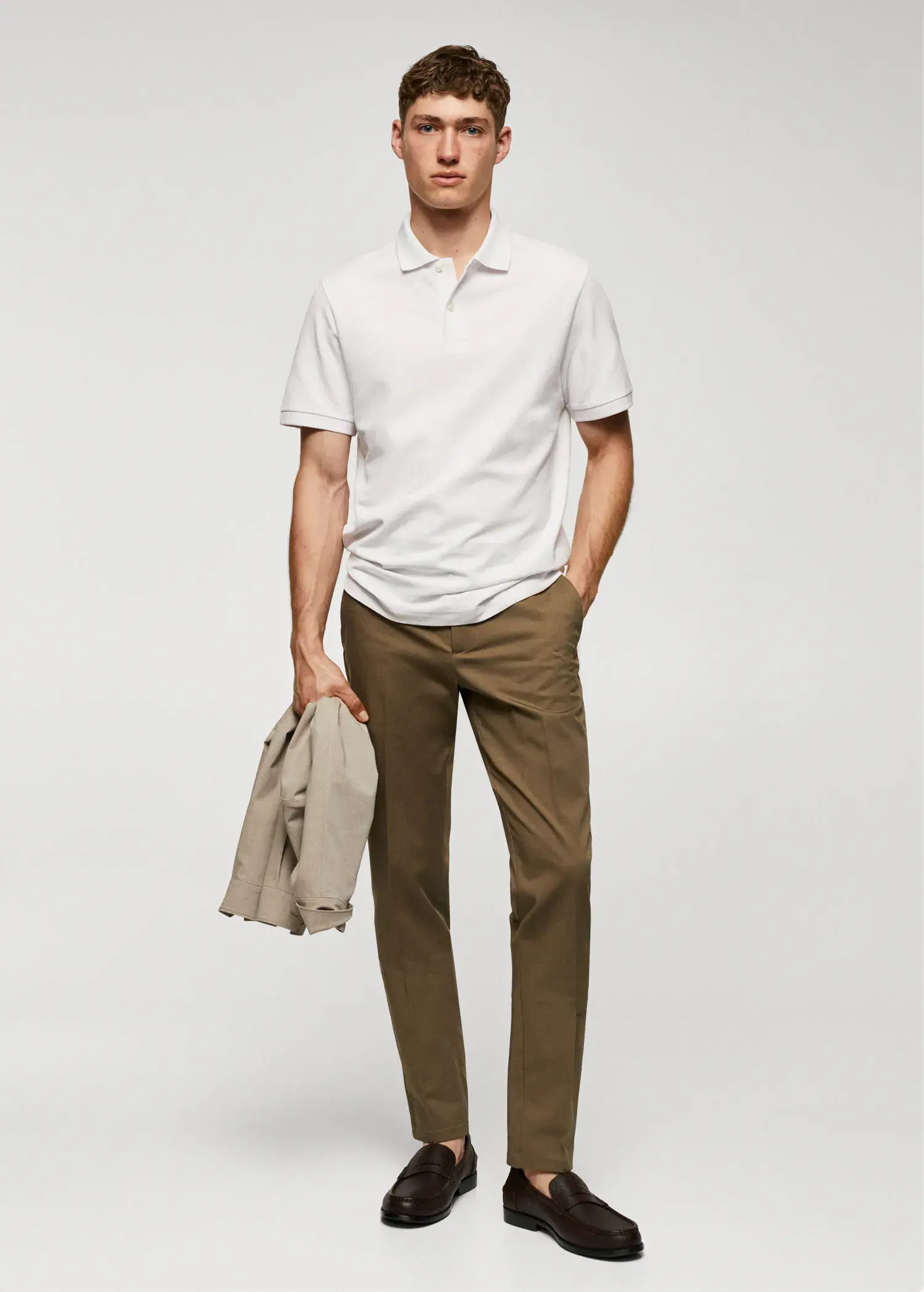 Mango Slim fit chino trousers. a man in a white shirt holding a jacket. 