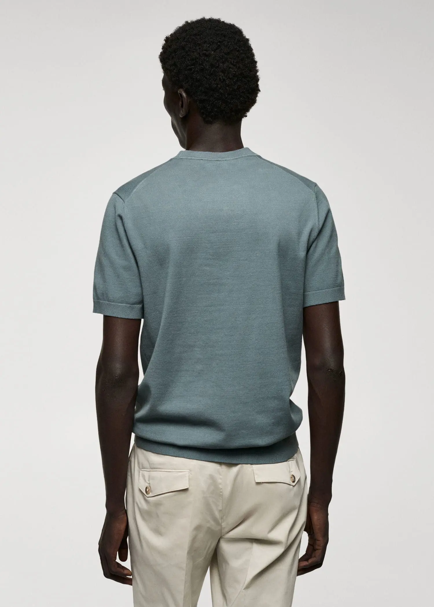 Mango Fine-knit T-shirt. a man wearing a blue shirt and beige shorts. 