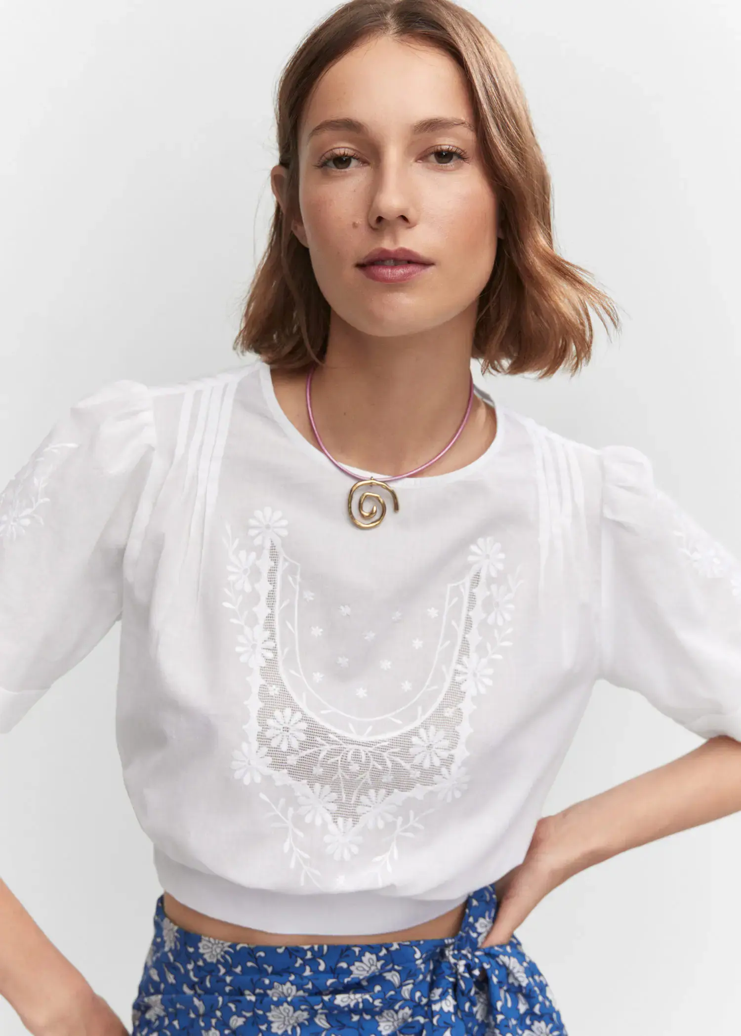 Mango Embroidered crop top. a woman wearing a white shirt and a necklace. 