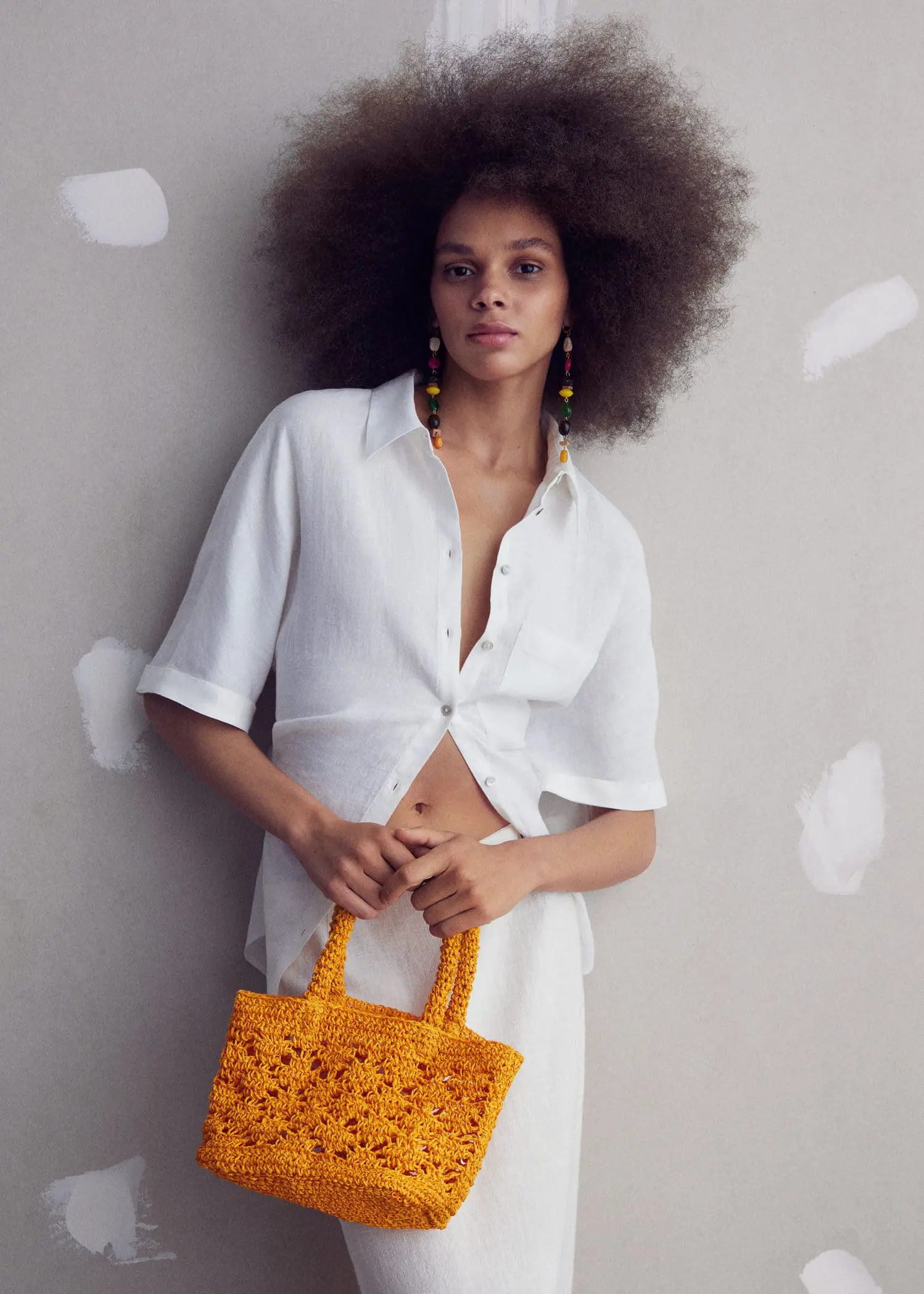 Mango Double-handle raffia bag. a woman holding a yellow bag in her hands. 