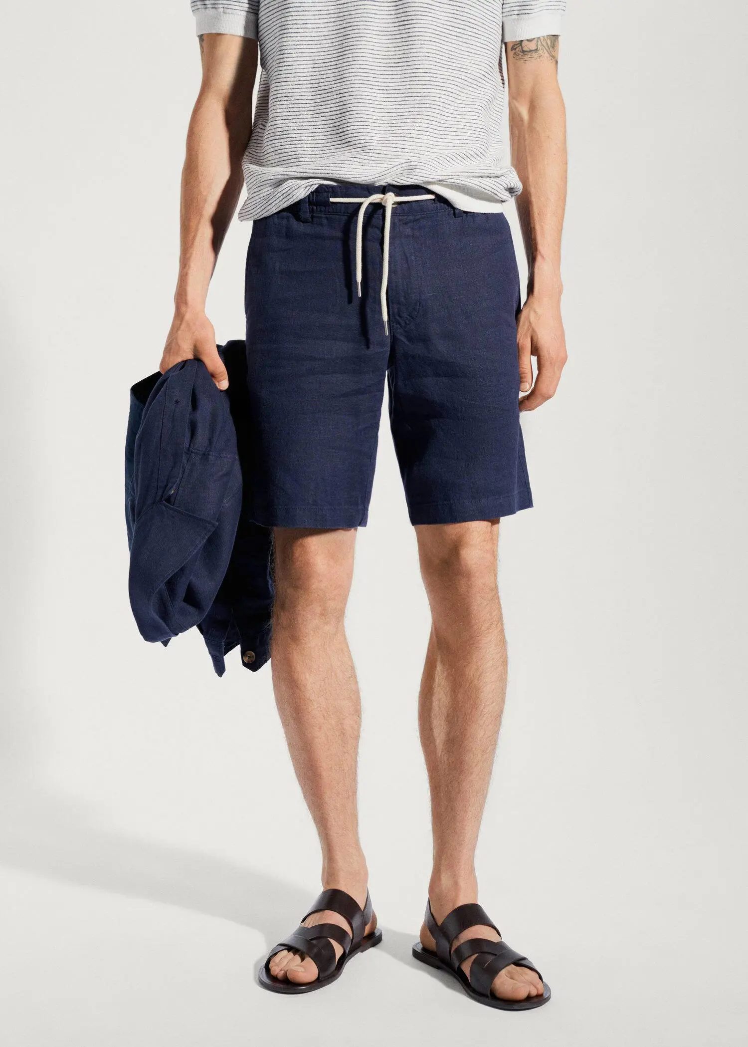 Mango 100% linen bermuda shorts with drawstring. a man in blue shorts holding a jacket. 