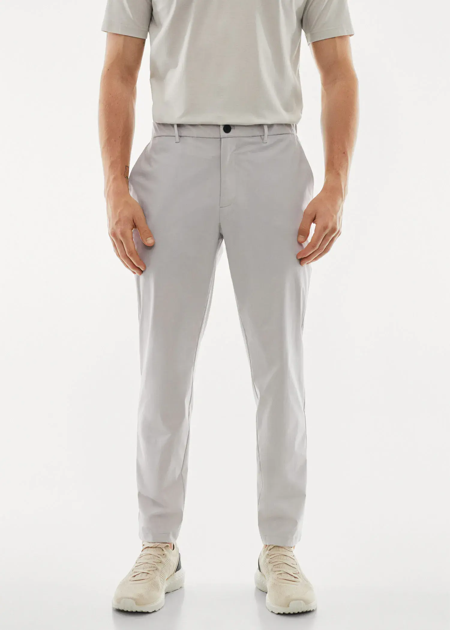 Mango Water-repellent technical trousers. a man wearing a white shirt and gray pants. 